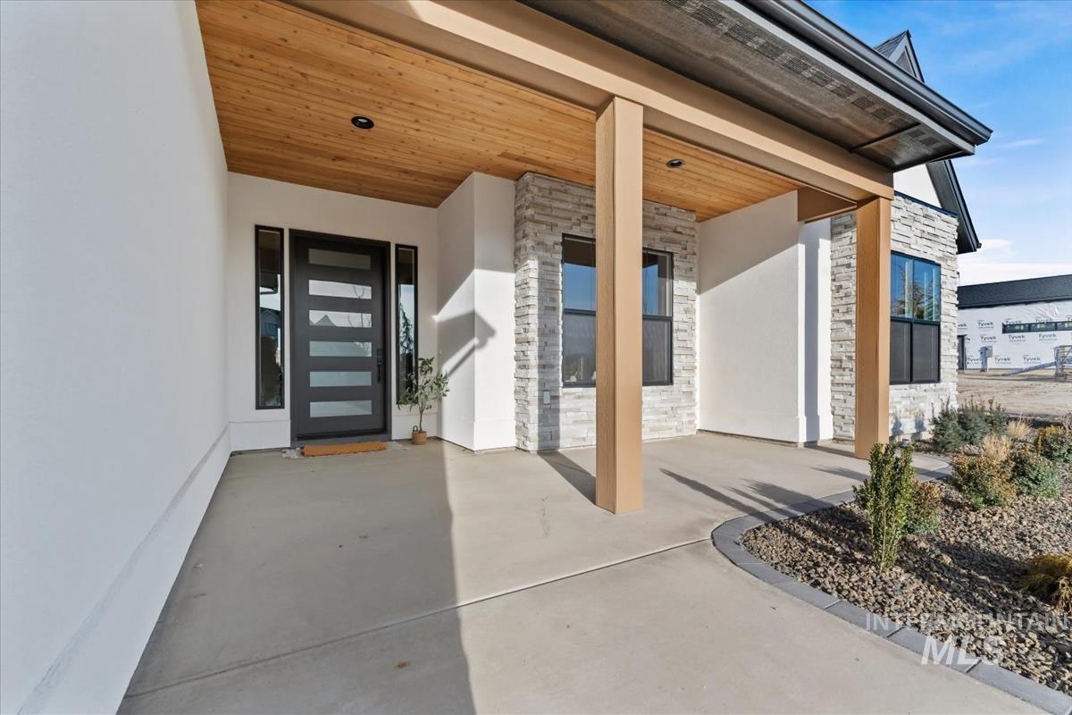 View of exterior entry featuring stone siding and stucco siding