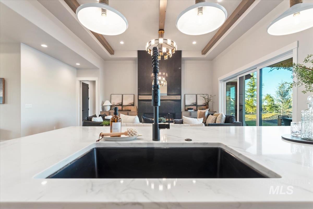 Kitchen featuring light stone countertops, a tray ceiling, and recessed lighting