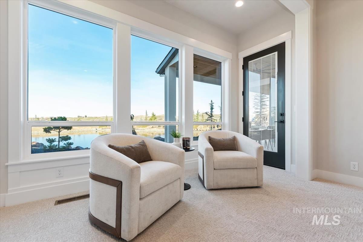 Living area featuring carpet flooring, healthy amount of natural light, and a water view