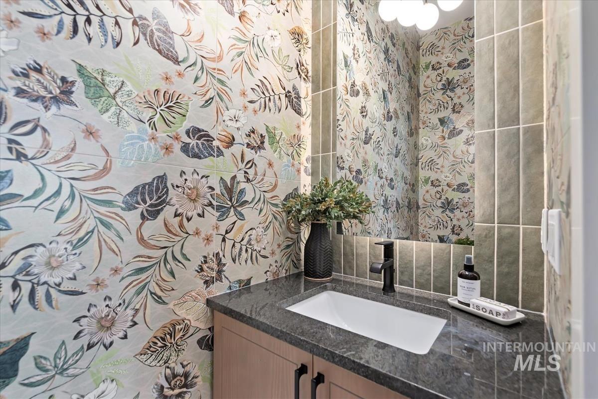 Bathroom featuring vanity and tasteful backsplash