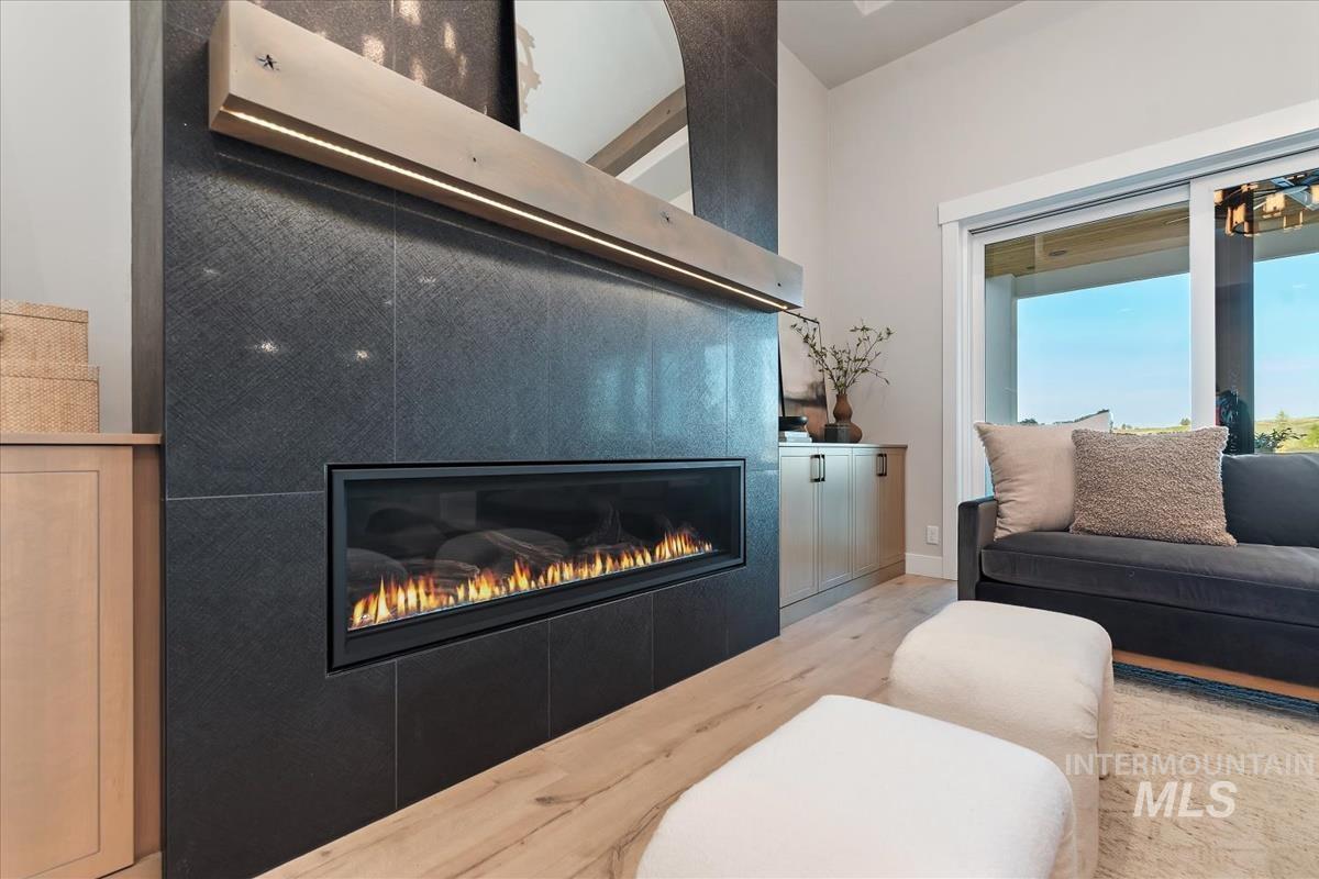 Living area with a glass covered fireplace and wood finished floors