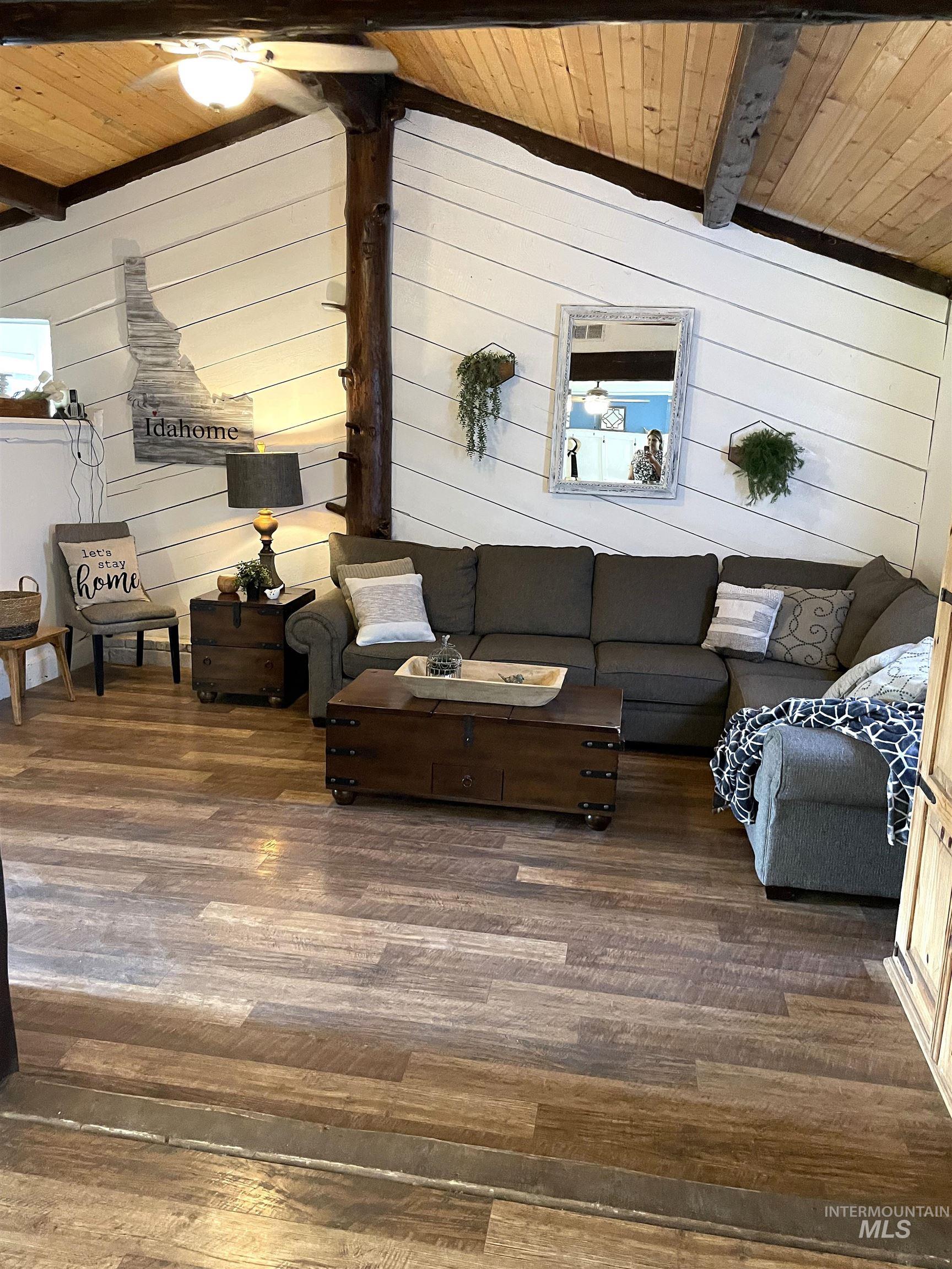 Living area with wooden walls, wooden ceiling, and wood-type flooring