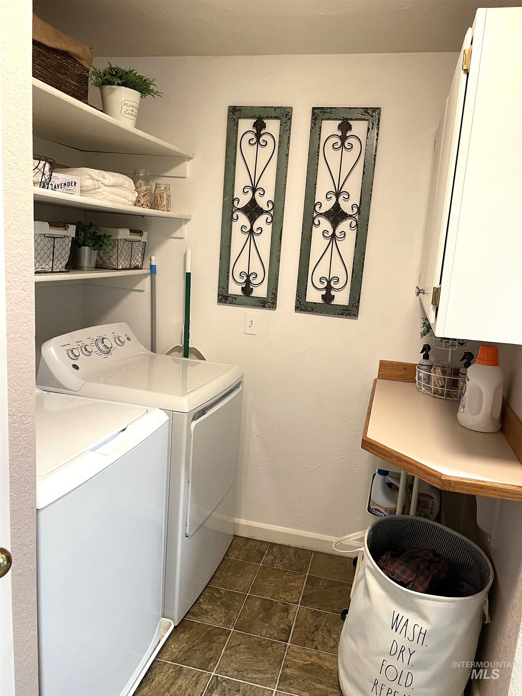 Laundry room with baseboards and washer and clothes dryer