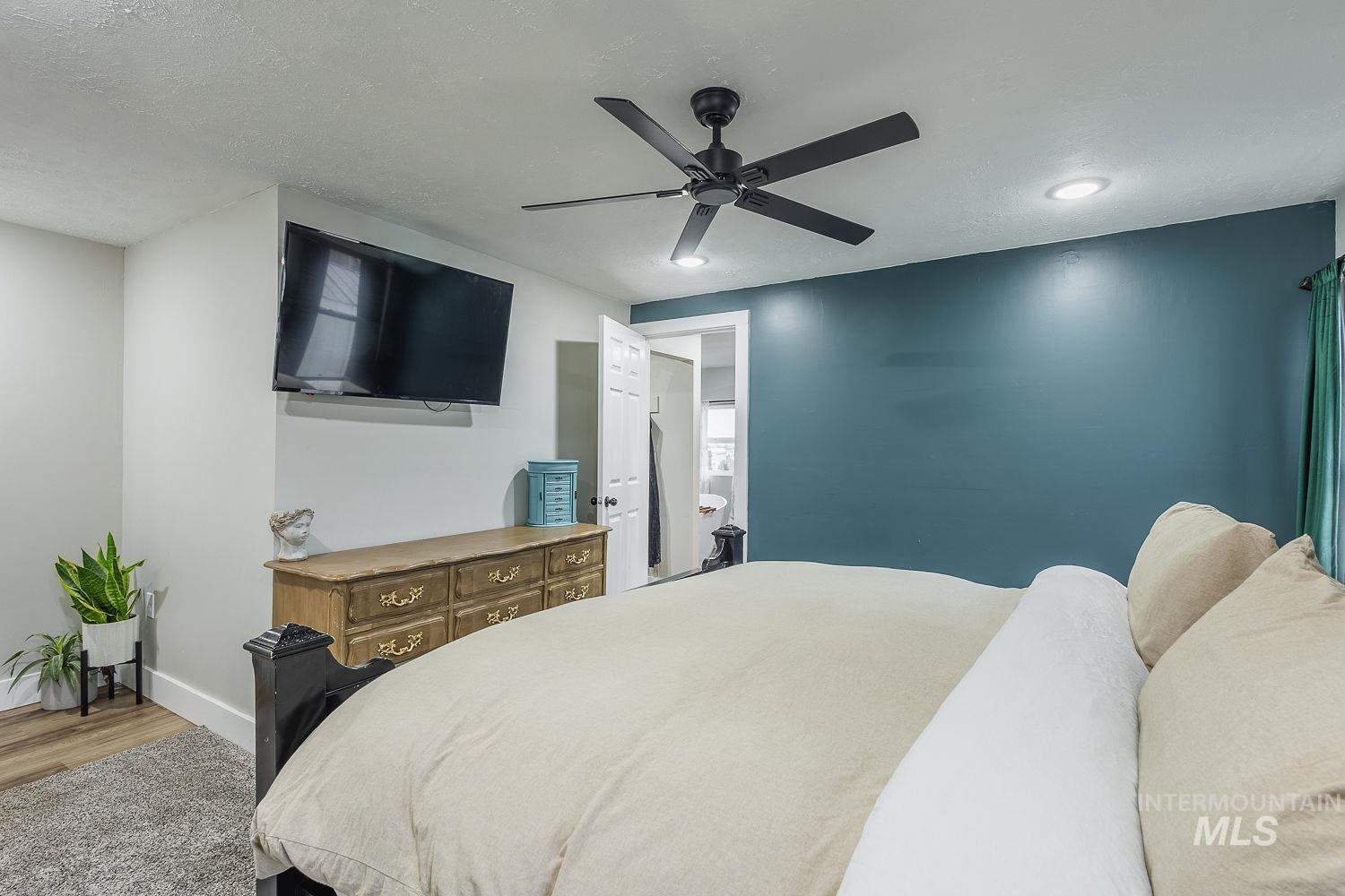 Bedroom featuring a ceiling fan, a textured ceiling, and light wood finished floors