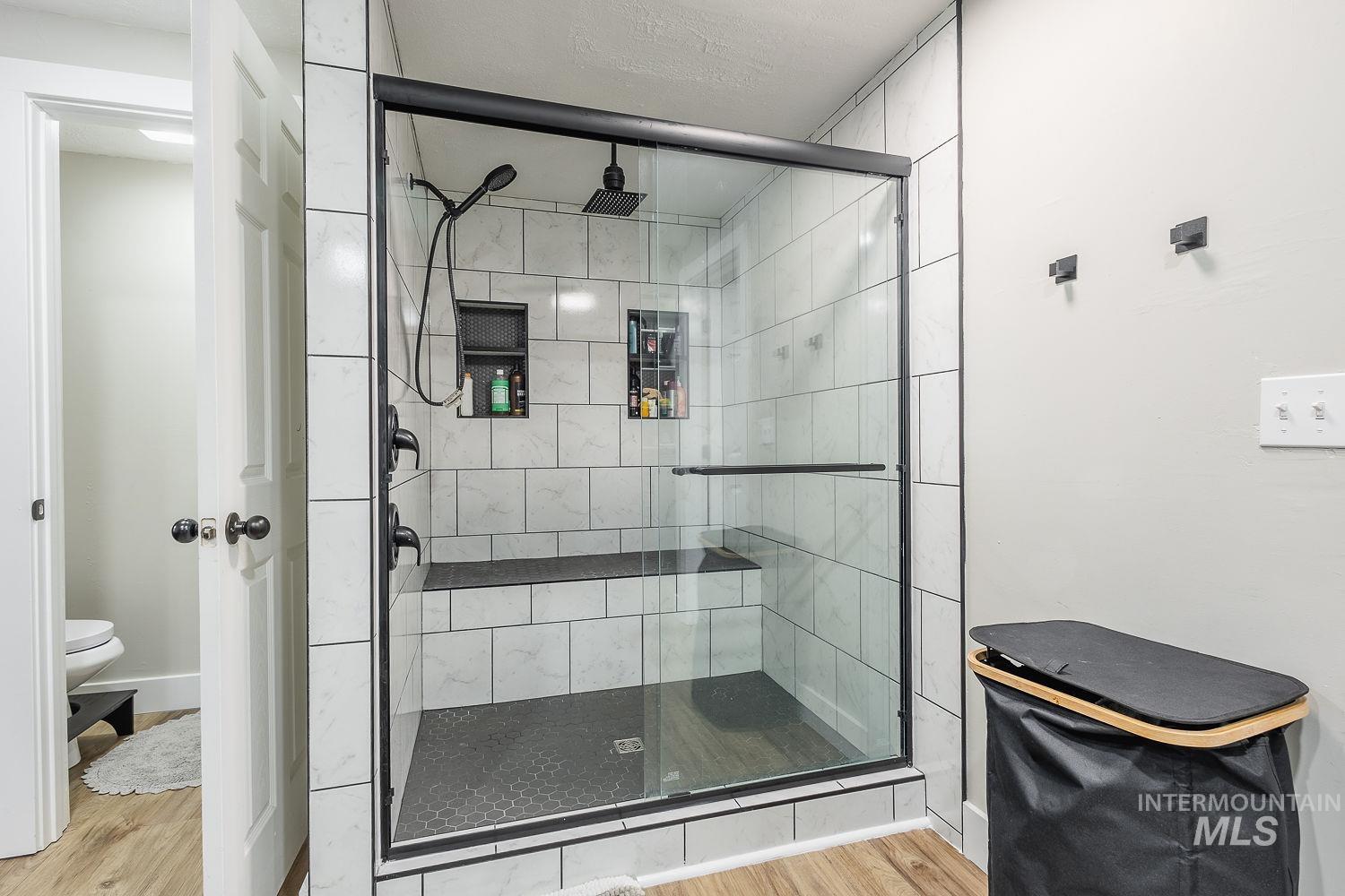 Bathroom with light wood-type flooring and a shower stall