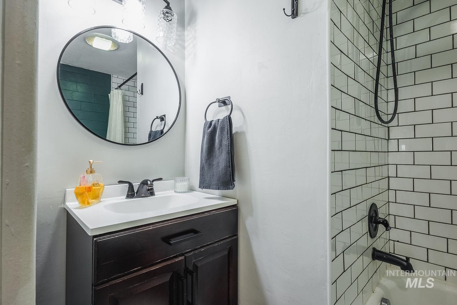 Full bathroom with shower / bath combo and vanity