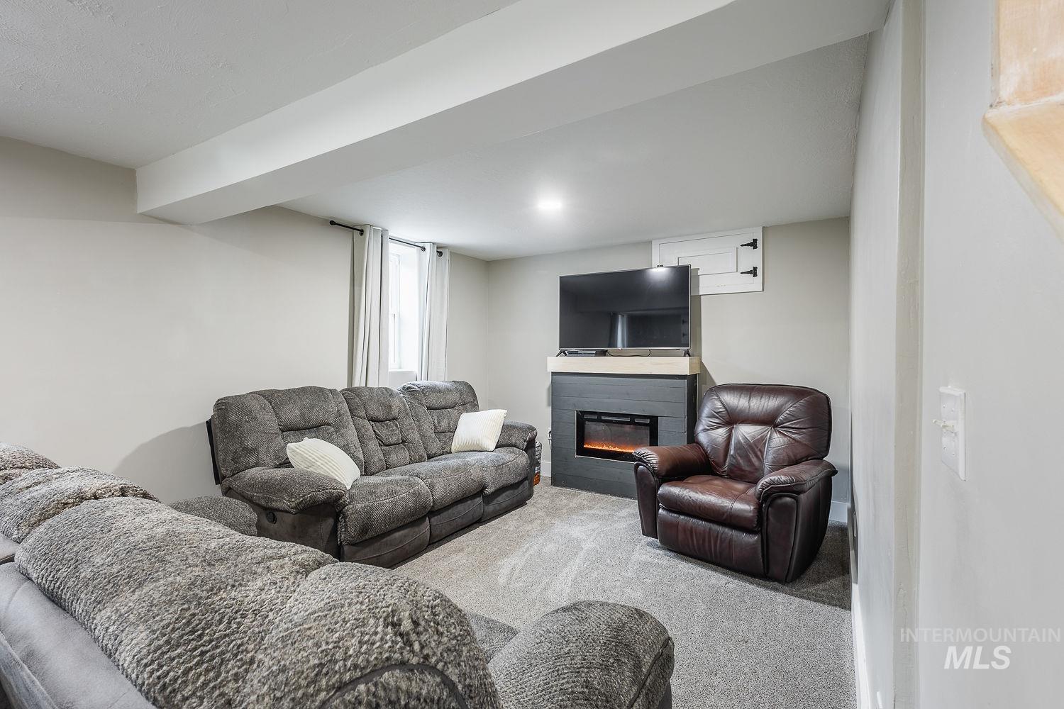 Living area featuring carpet flooring and a glass covered fireplace