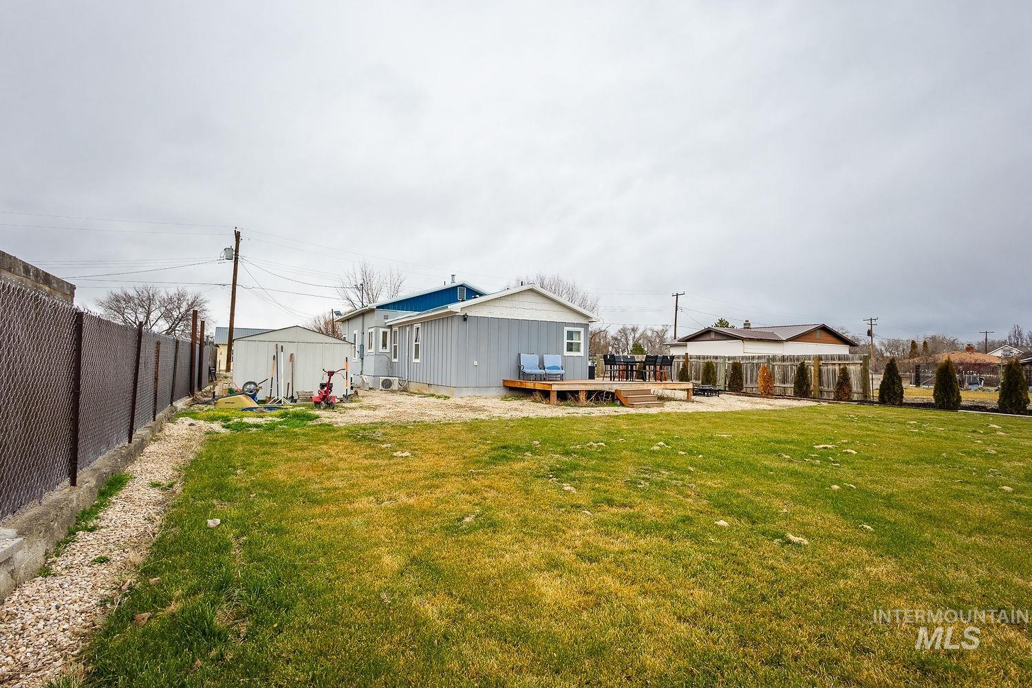Rear view of house featuring a wooden deck, a fenced backyard, and an outdoor structure