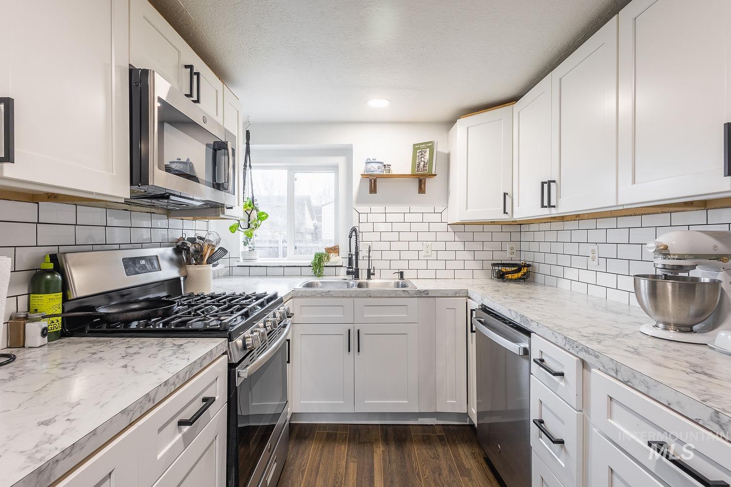 Kitchen featuring stainless steel appliances, white cabinets, light countertops, open shelves, and recessed lighting