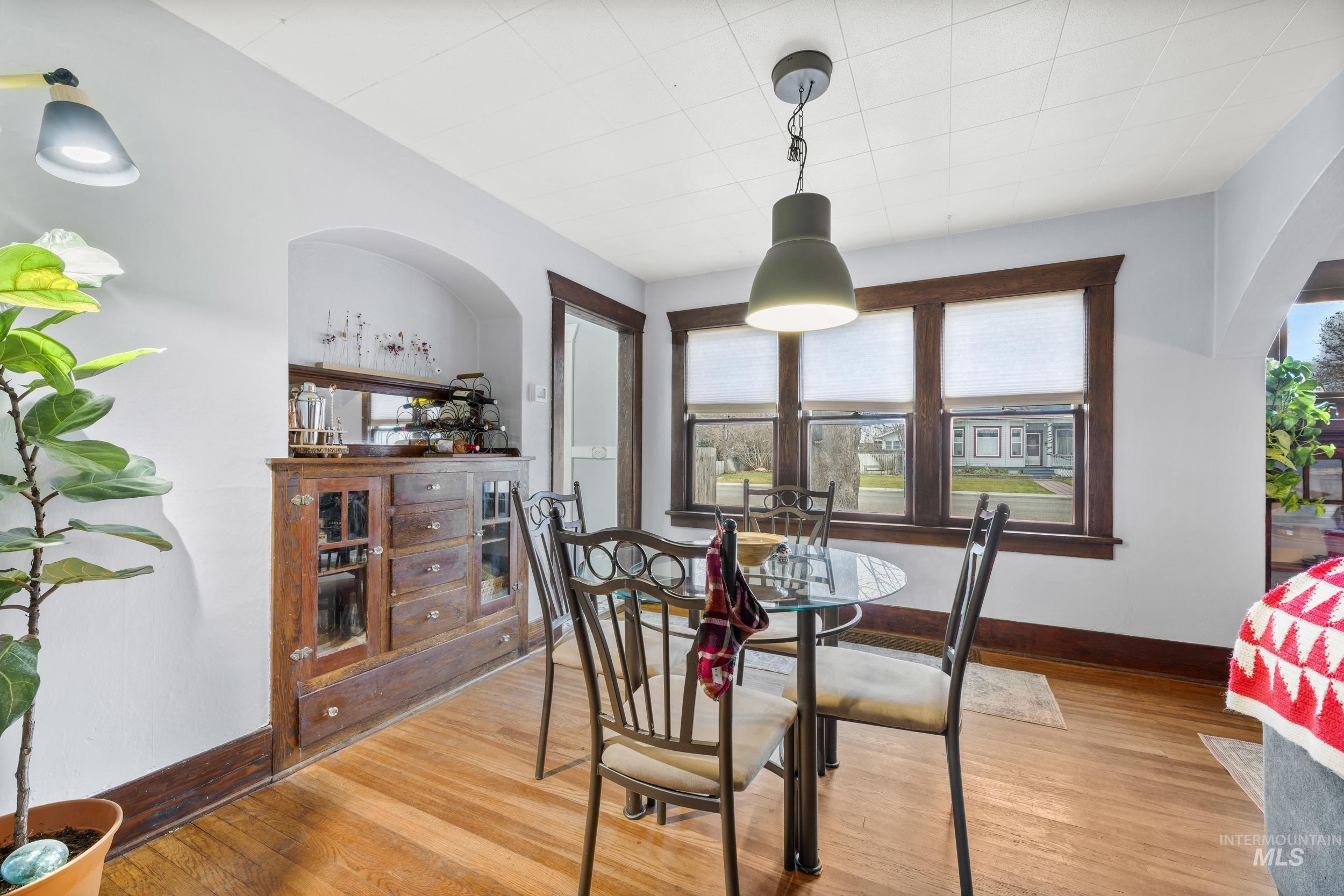 Dining area with light wood-type flooring and arched walkways