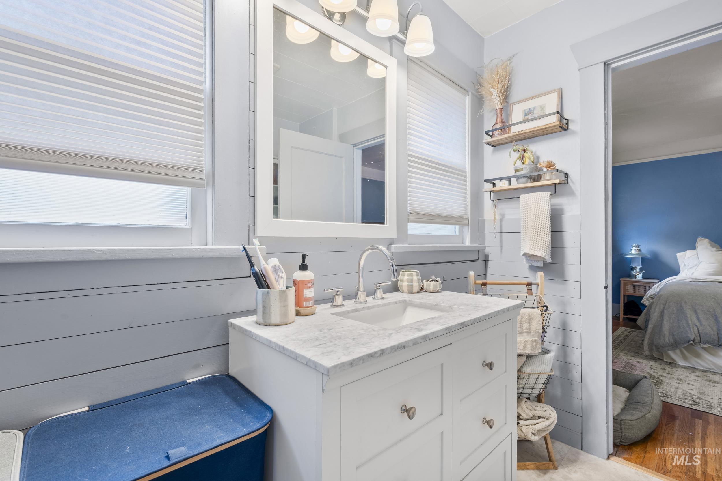 Bathroom featuring connected bathroom, vanity, and healthy amount of natural light