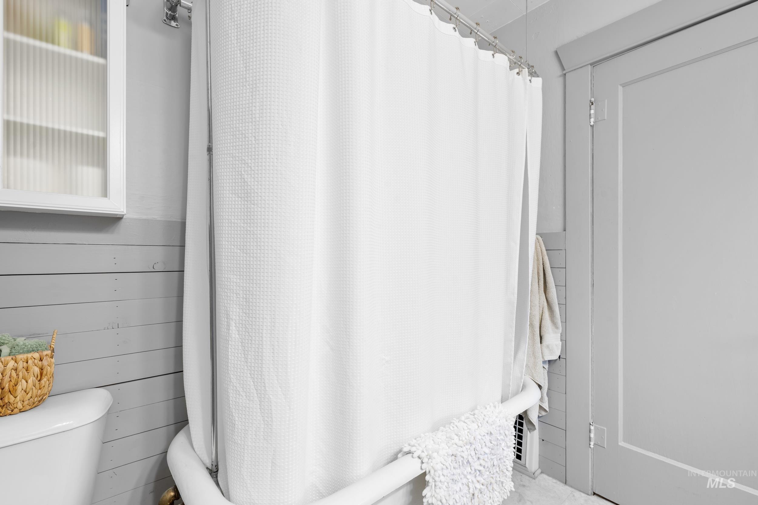 Bathroom featuring curtained shower and toilet