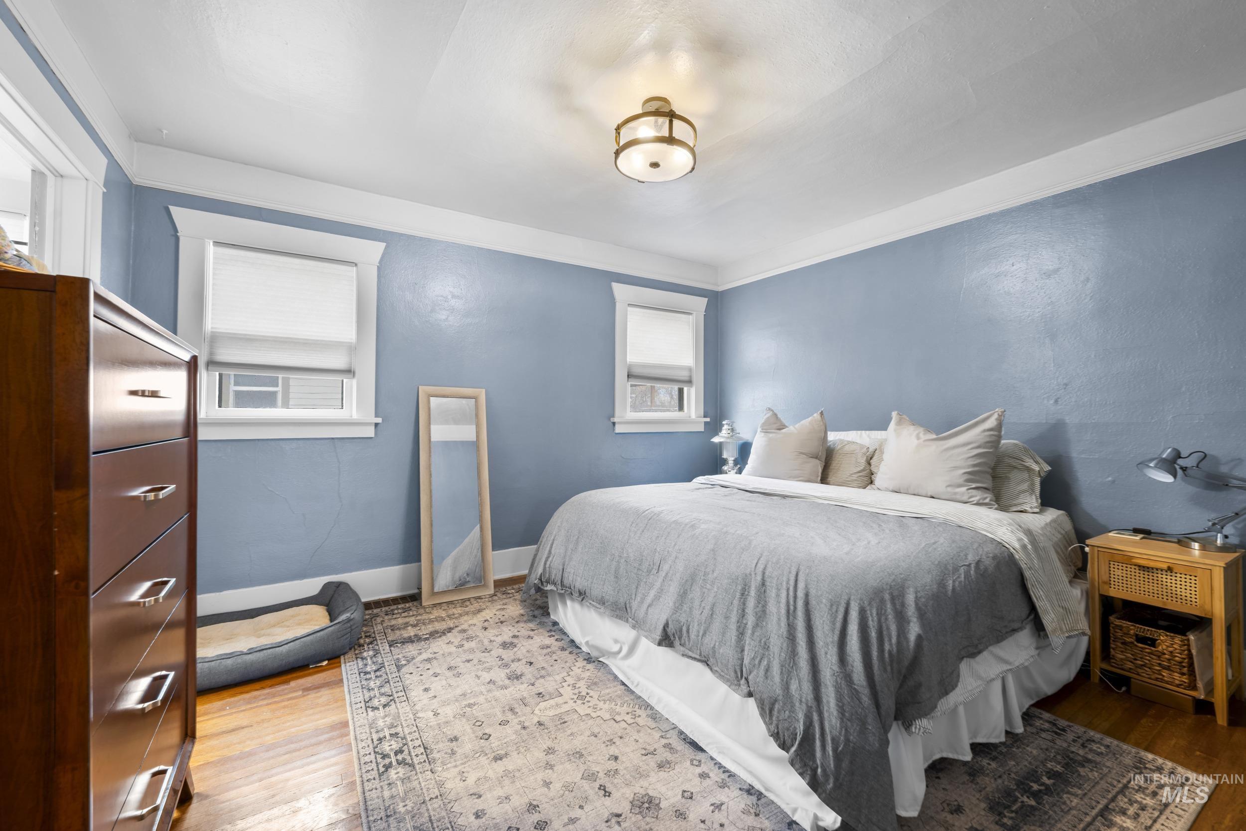 Bedroom with wood finished floors and baseboards