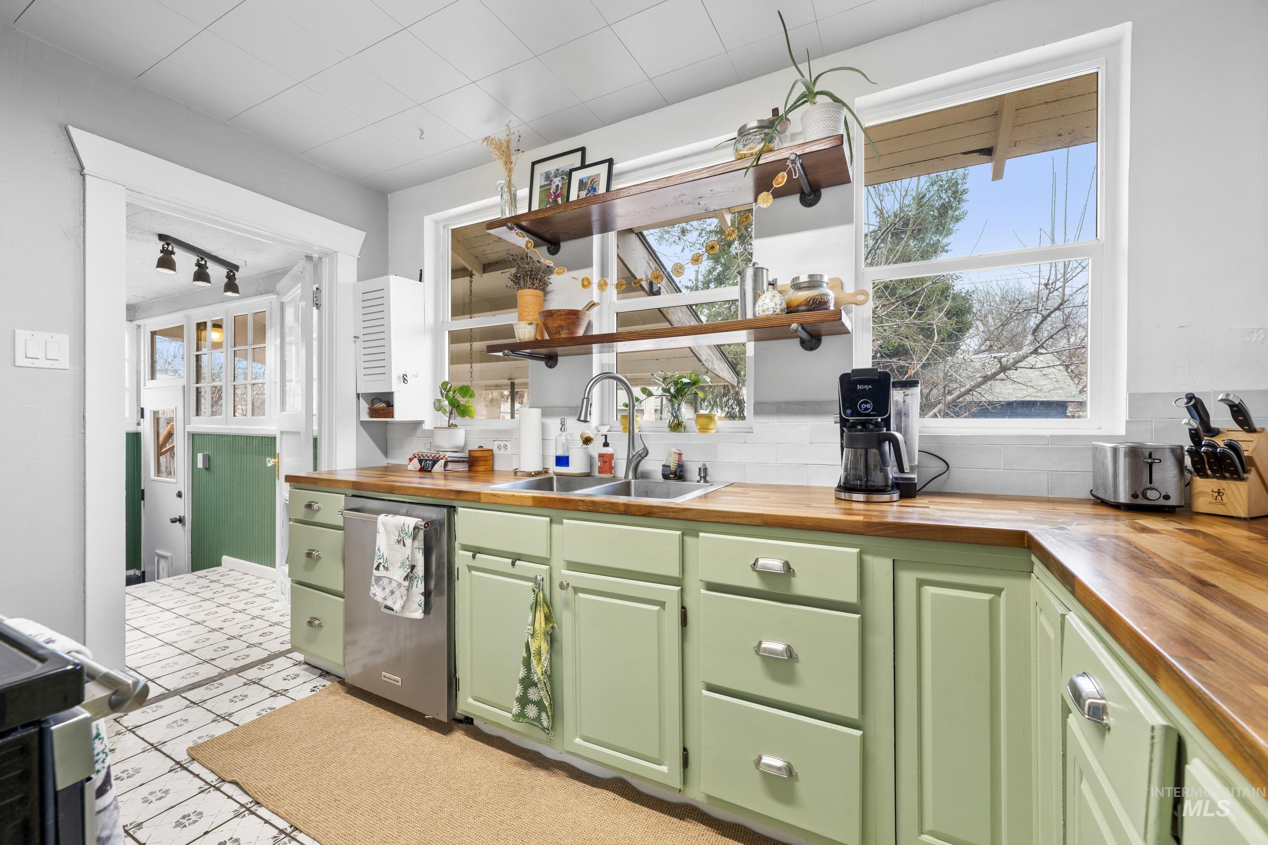 Bar area featuring wood counters, green cabinets, open shelves, dishwasher, and stove