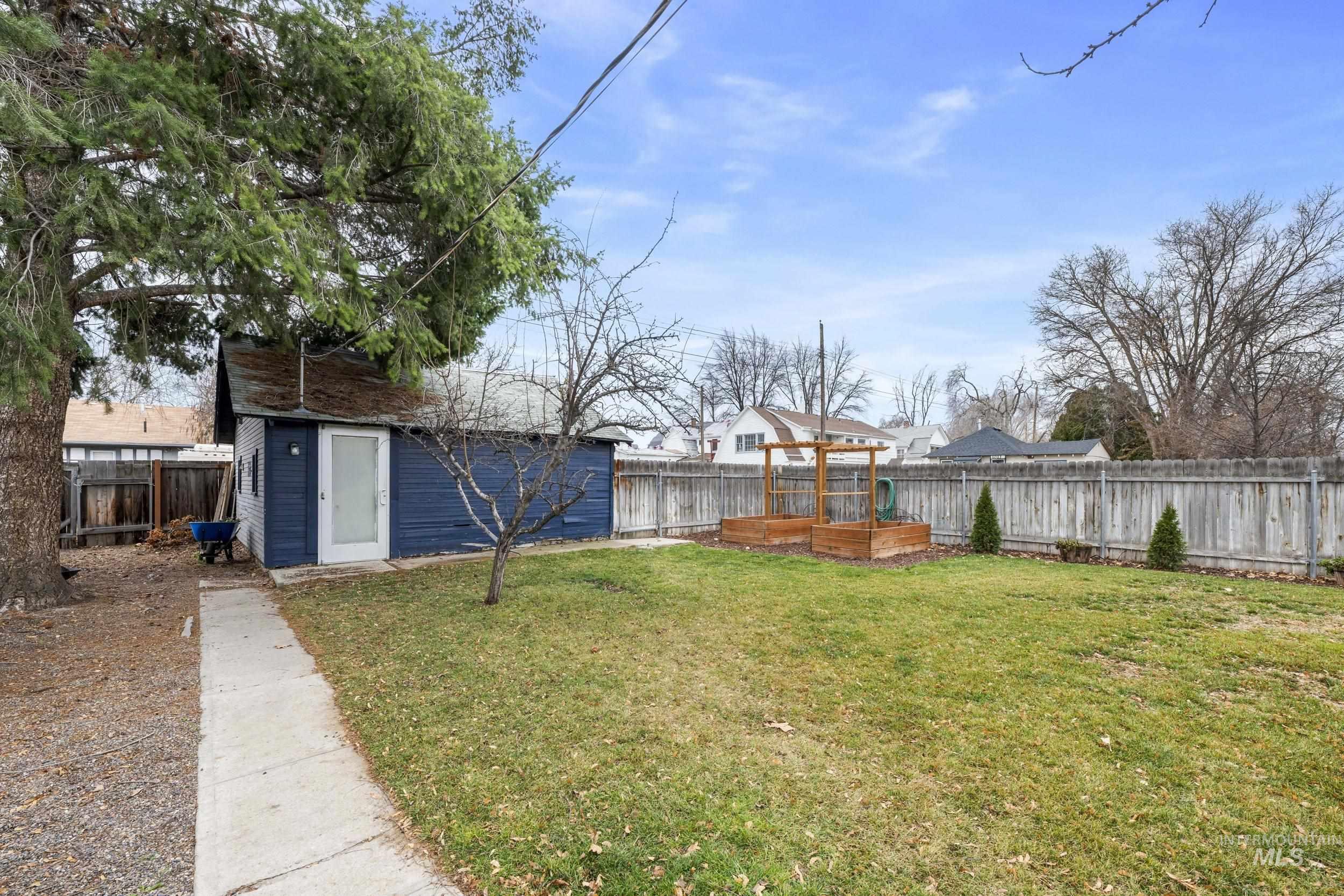 Fenced backyard with an outbuilding