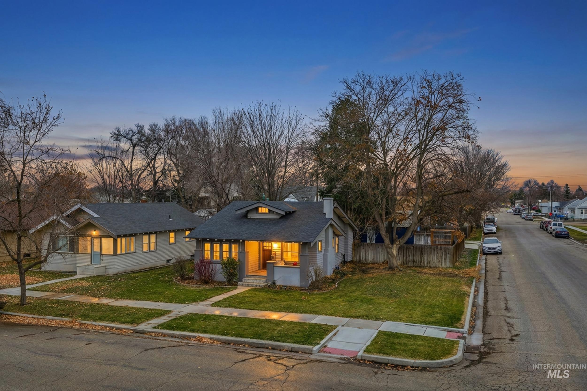 Bungalow-style home with a chimney, covered porch, and roof with shingles