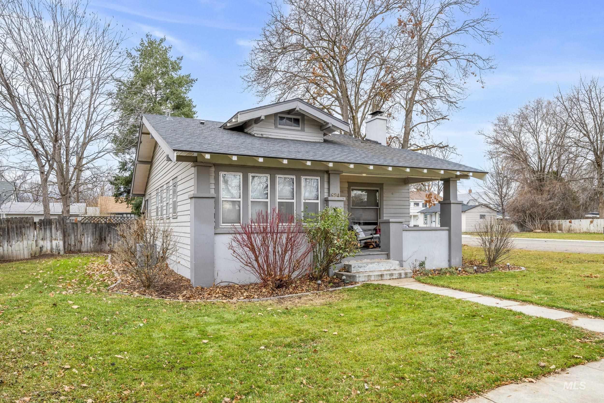 Bungalow-style home featuring a shingled roof, covered porch, and a chimney