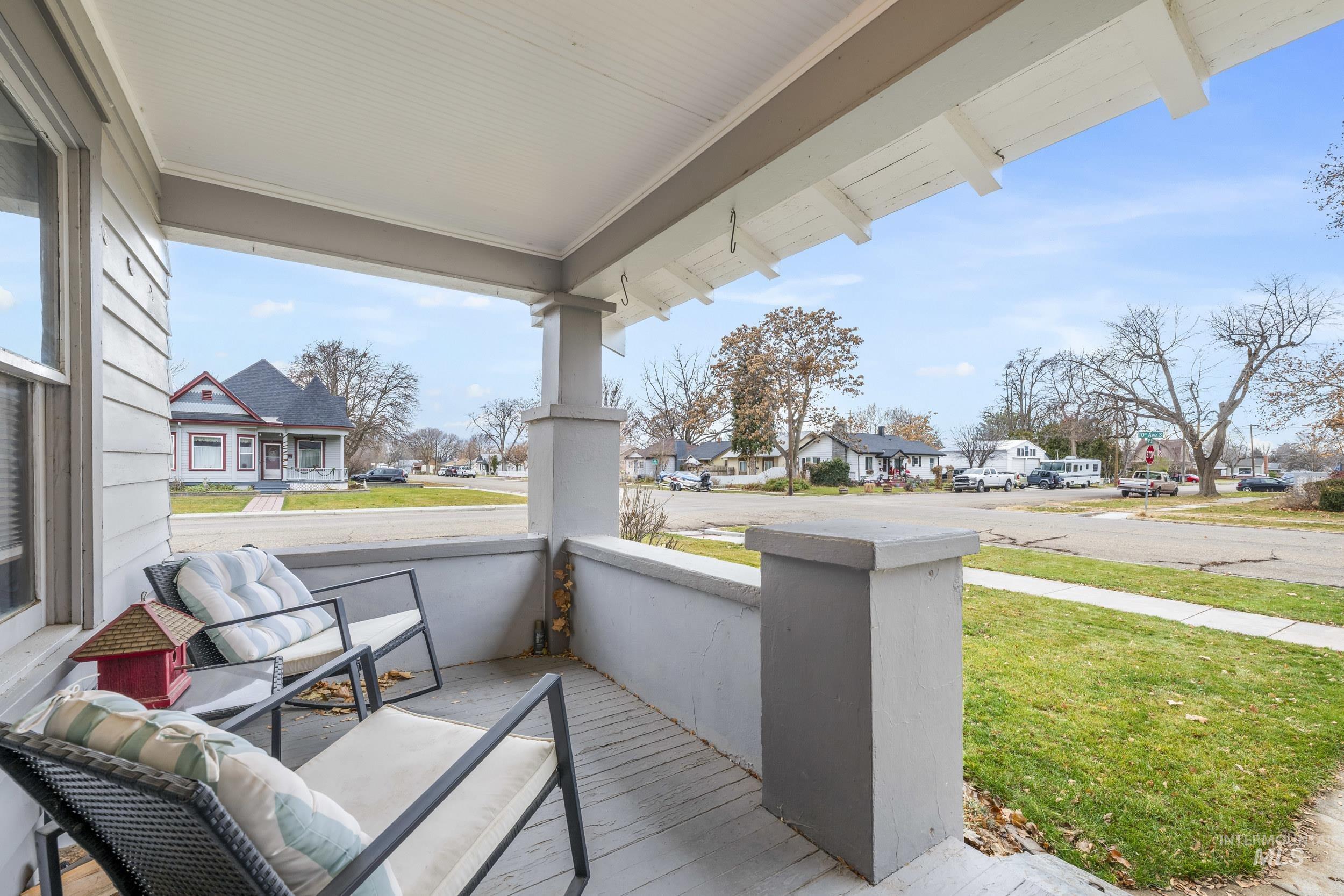 Covered porch featuring a residential view and a yard