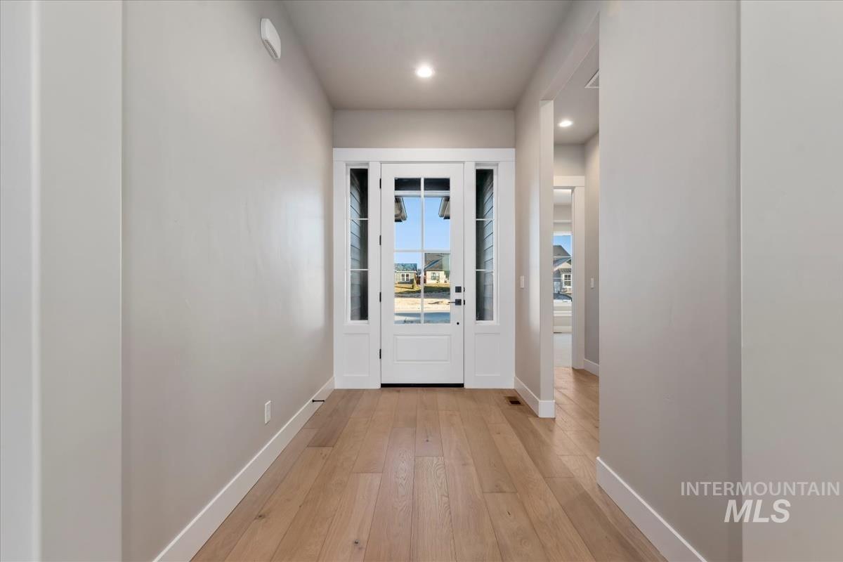 Doorway with wood-type flooring and recessed lighting