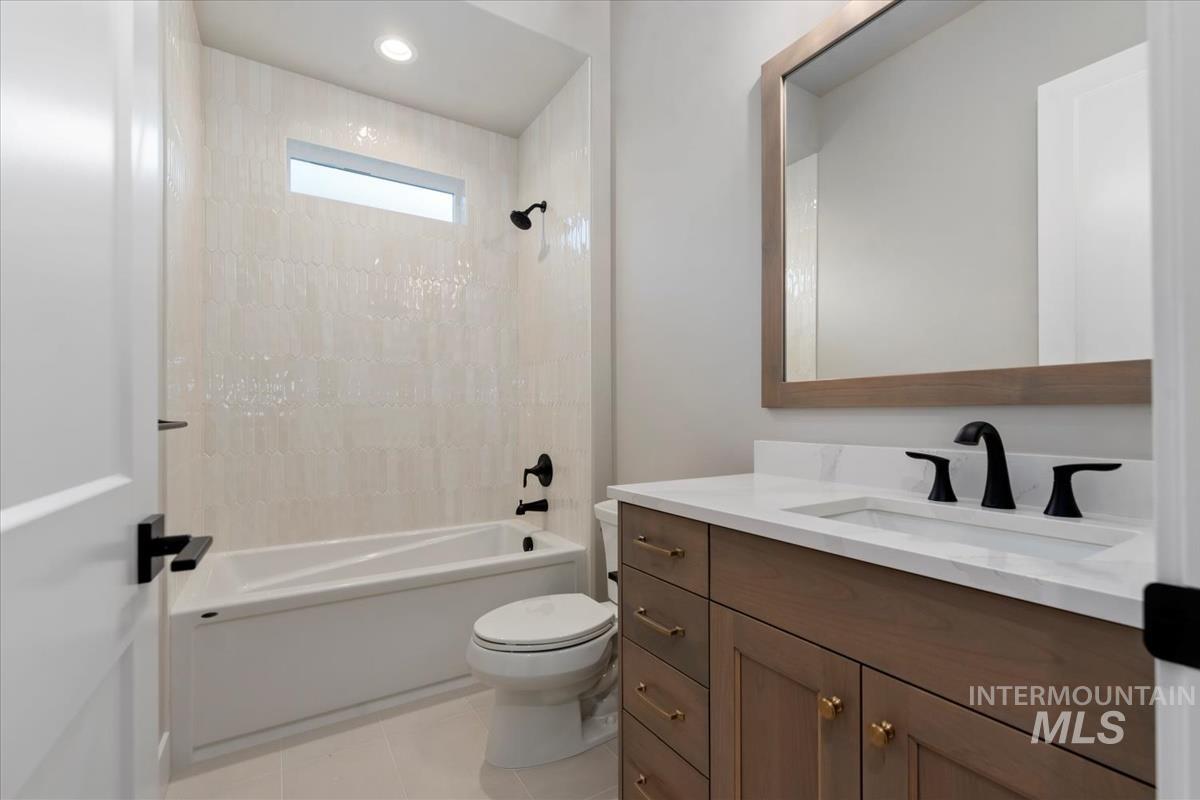 Full bath with shower / washtub combination, vanity, and light tile patterned floors