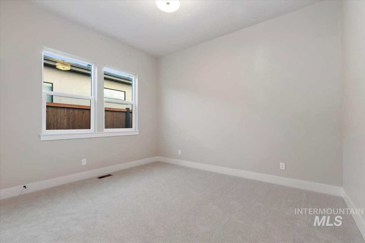 Empty room featuring baseboards and light carpet