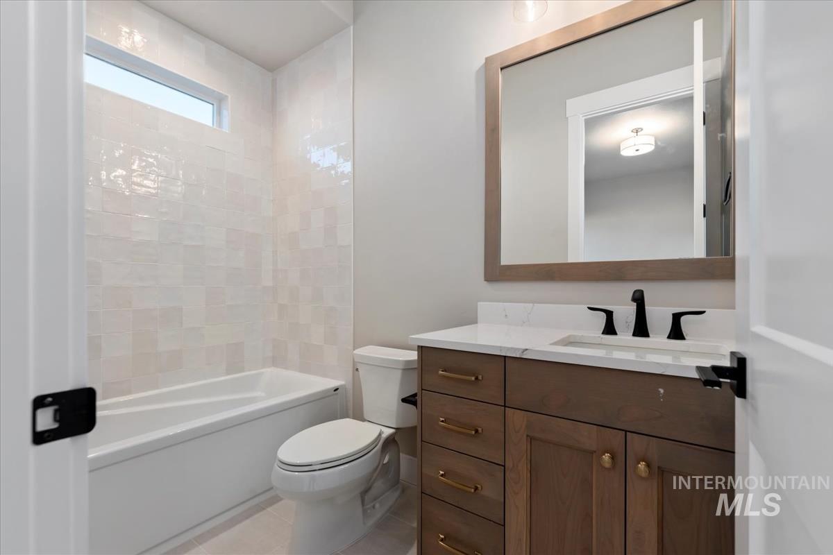 Bathroom with vanity, shower / washtub combination, and light tile patterned floors