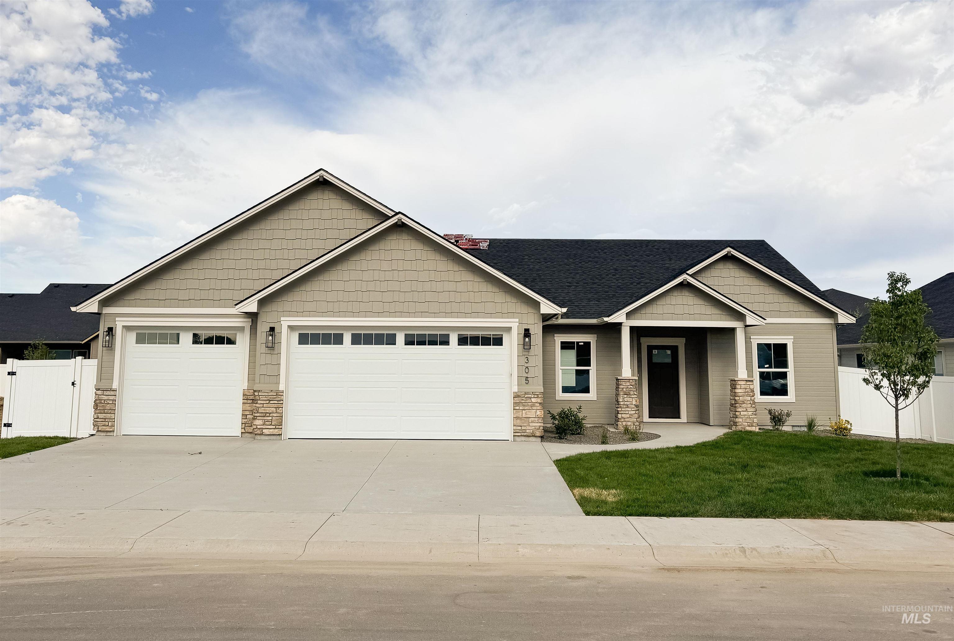 Craftsman-style house featuring concrete driveway, a garage, and stone siding