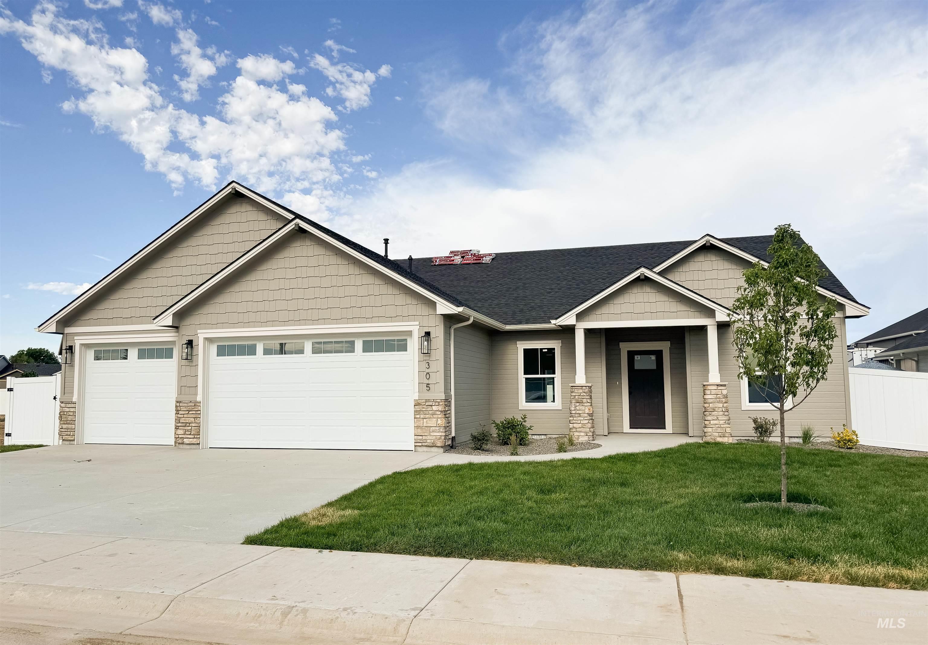 Craftsman inspired home featuring stone siding, a garage, and concrete driveway