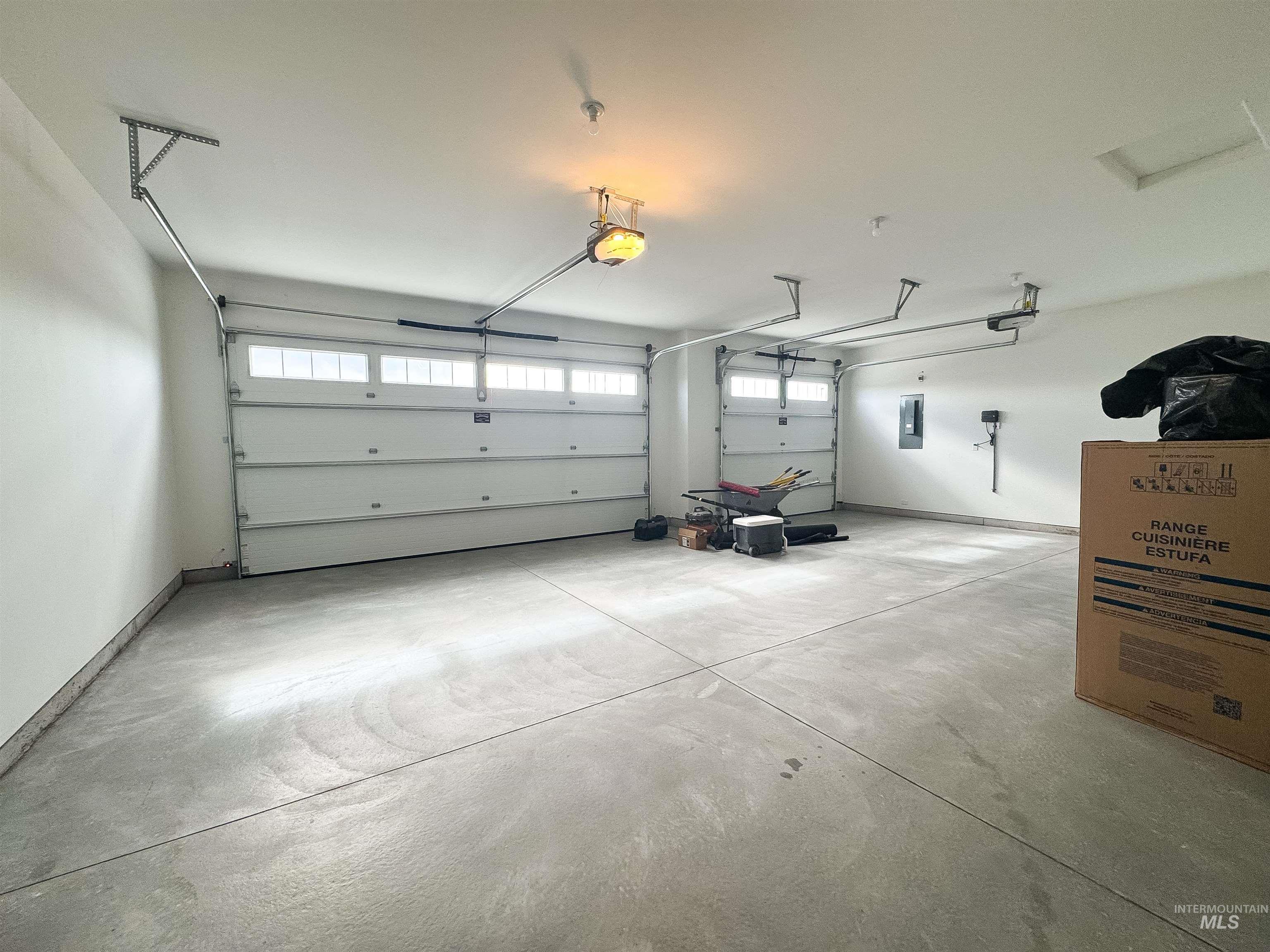 Garage featuring electric panel and a garage door opener