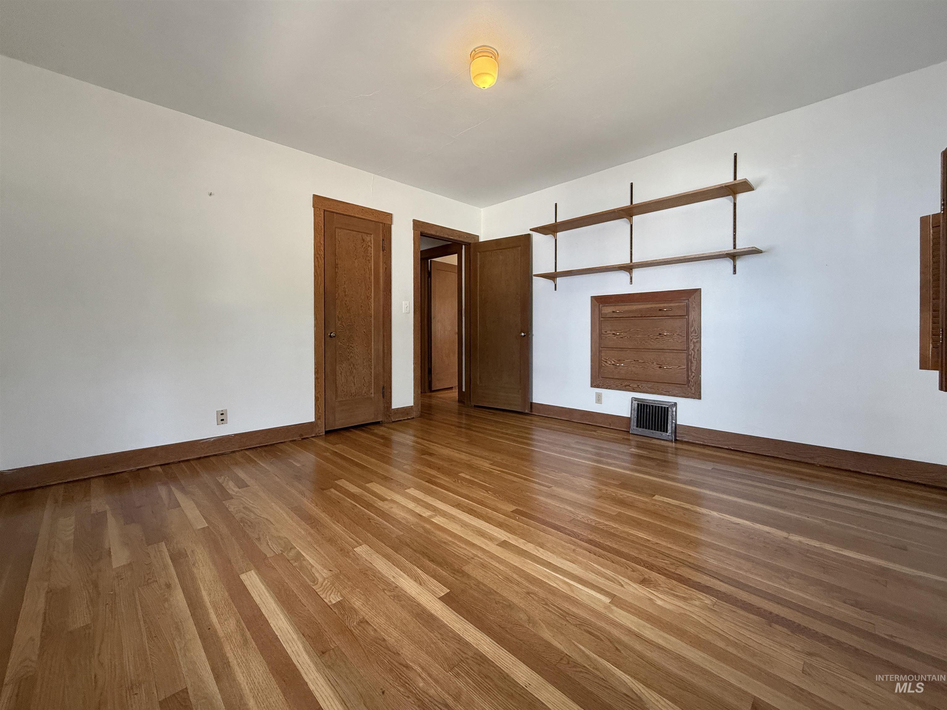 Empty room featuring light wood finished floors and baseboards
