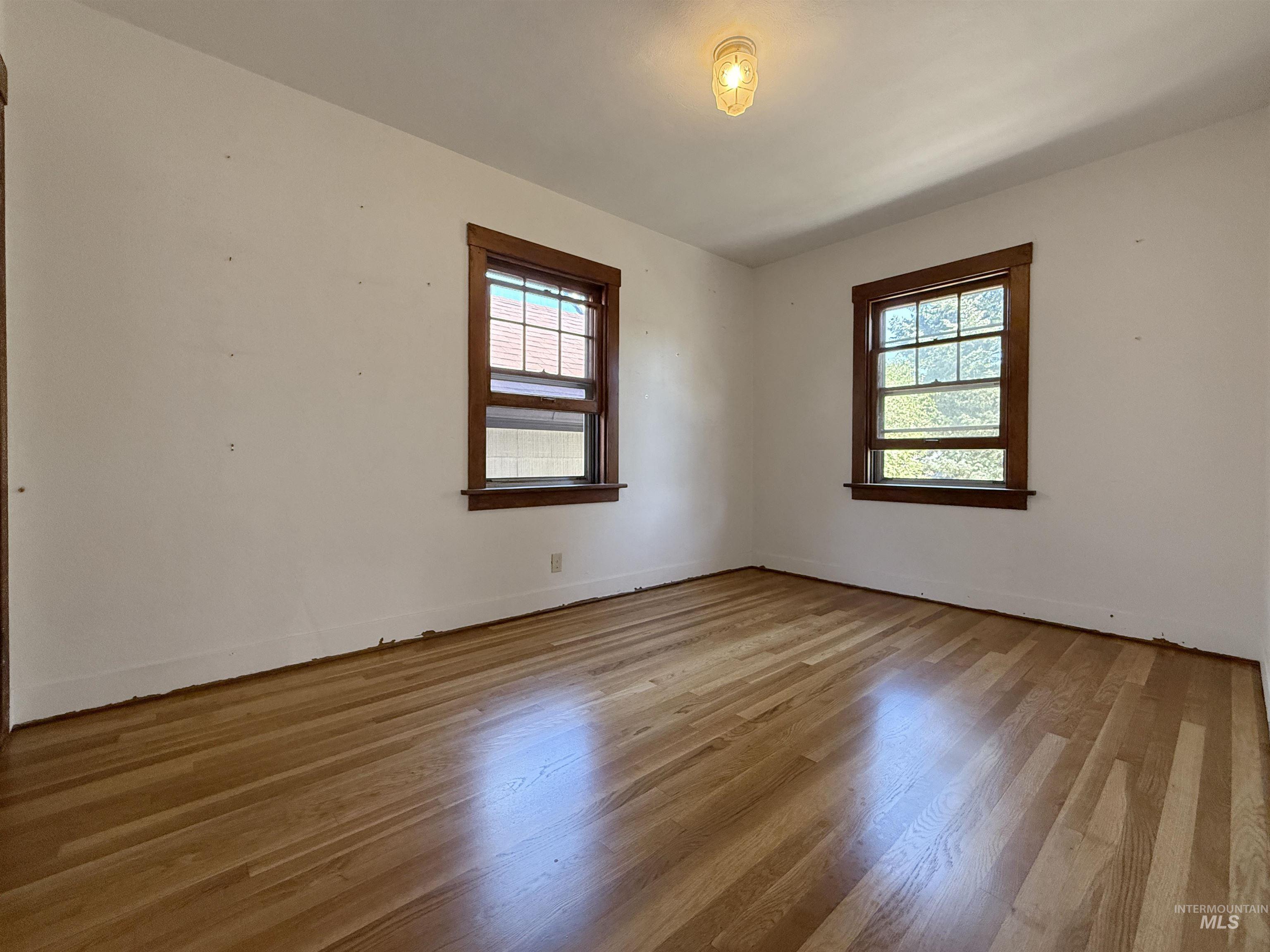 Empty room with light wood-style floors and baseboards