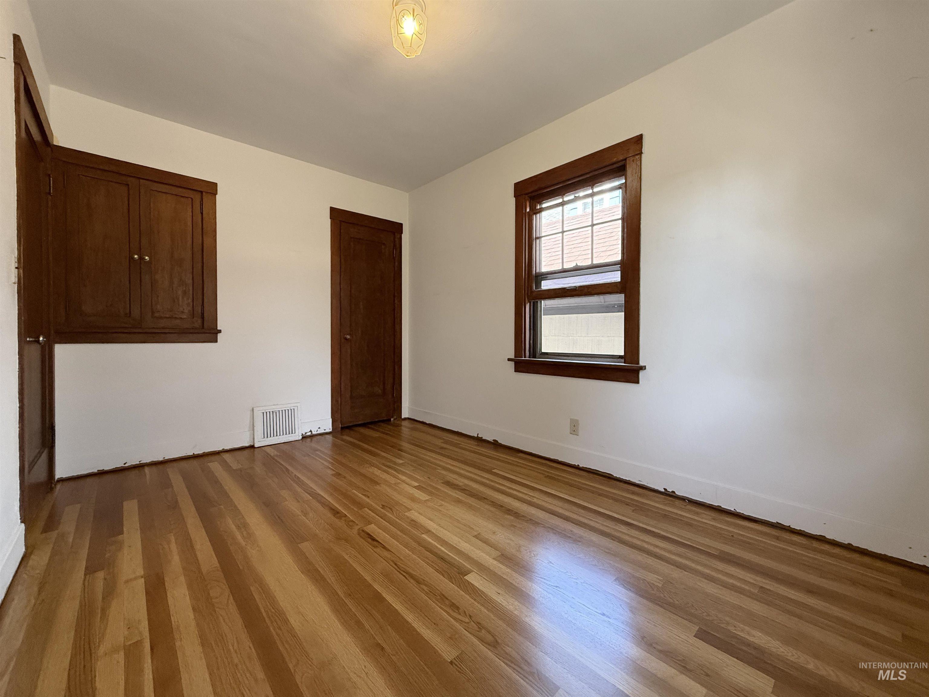 Empty room featuring wood finished floors and baseboards