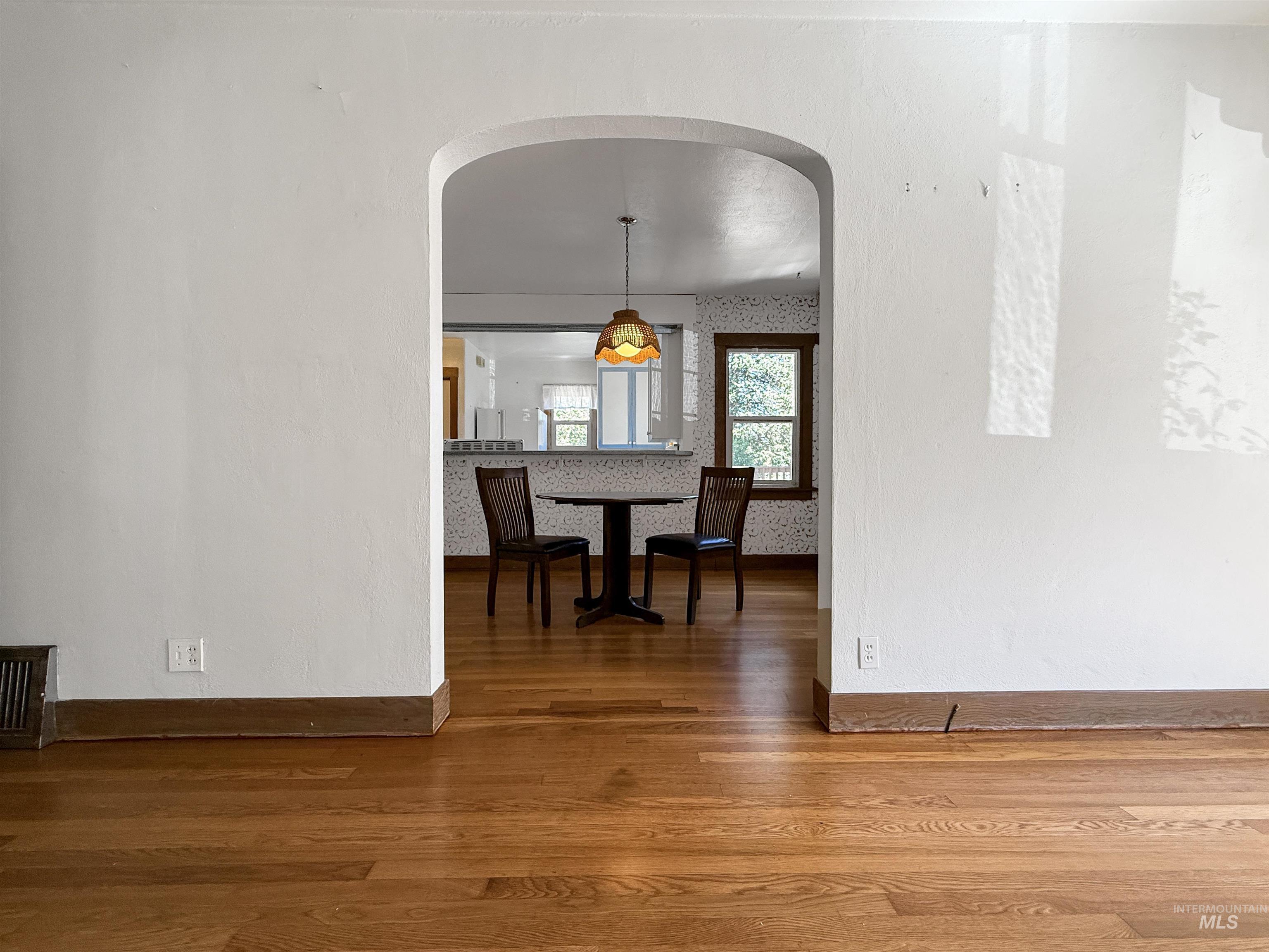Dining room with dark wood finished floors and arched walkways