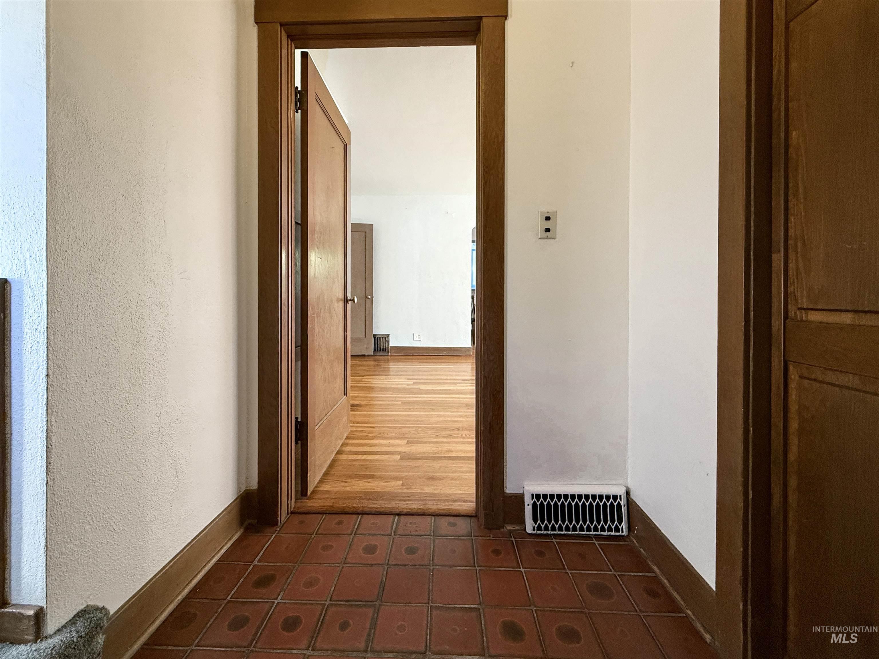 Hall with baseboards and a textured wall