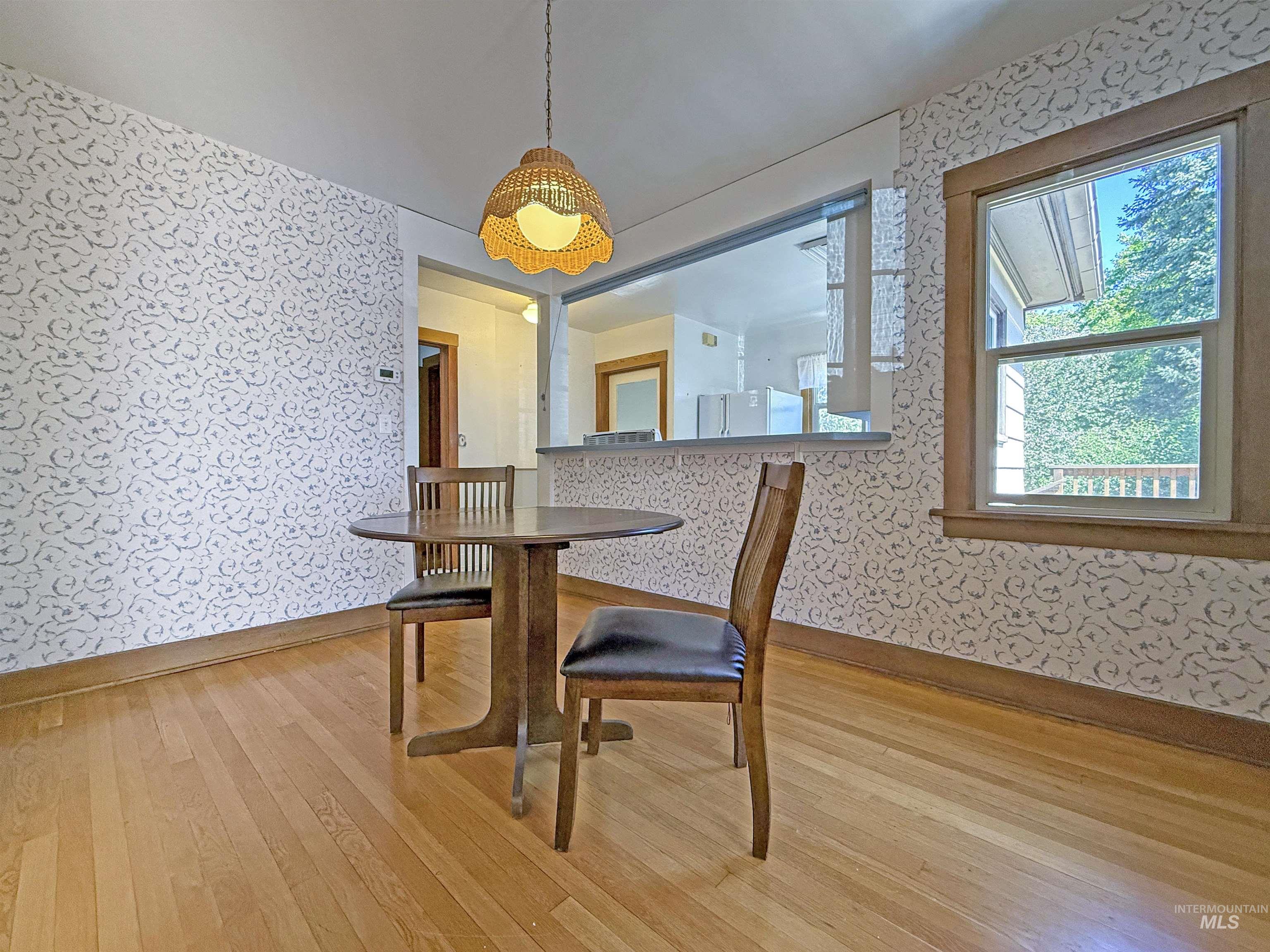 Dining area featuring wallpapered walls and light wood-type flooring