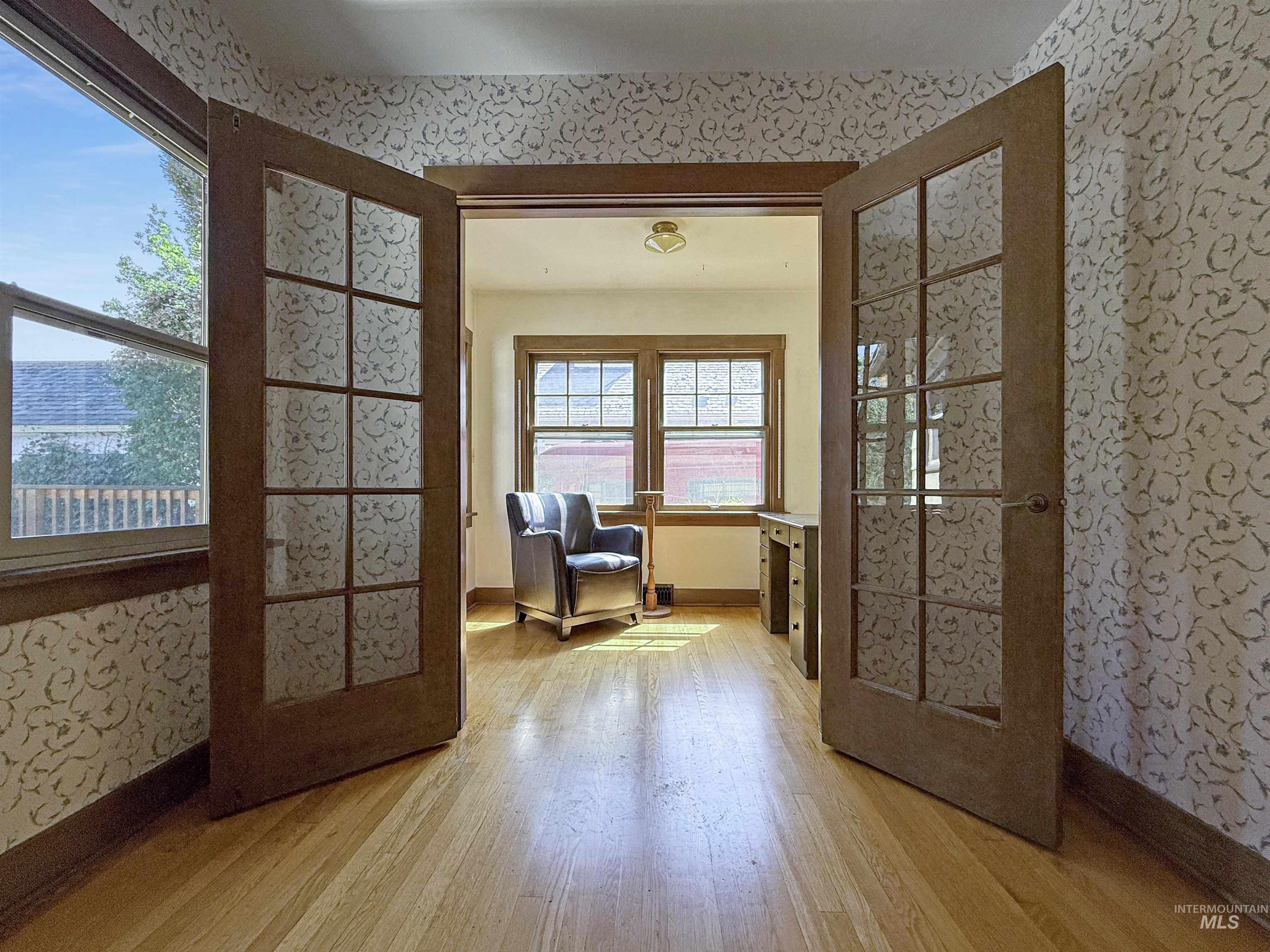 Sitting room featuring wallpapered walls and light wood-style flooring