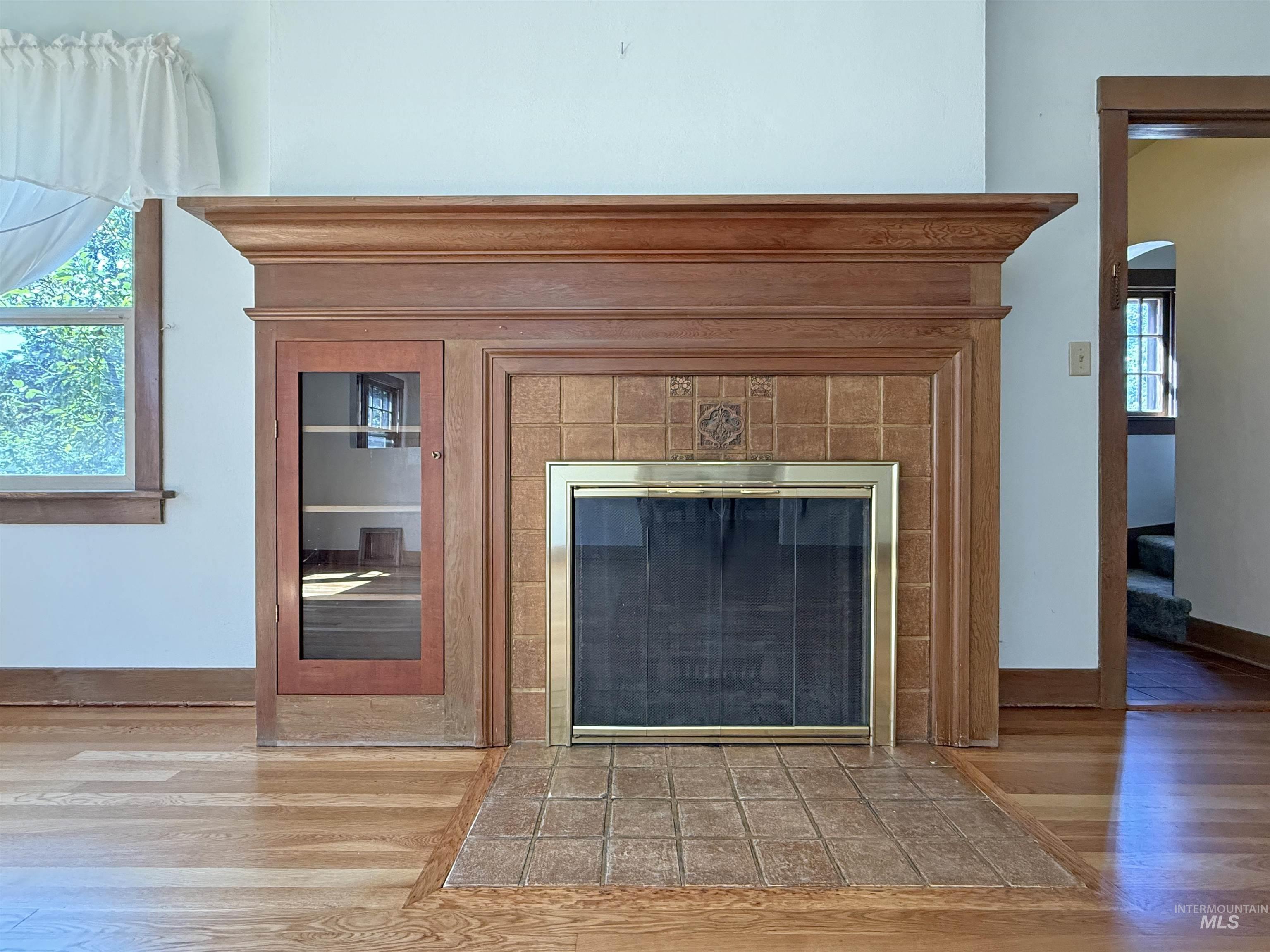 Detailed view of wood finished floors and a tile fireplace