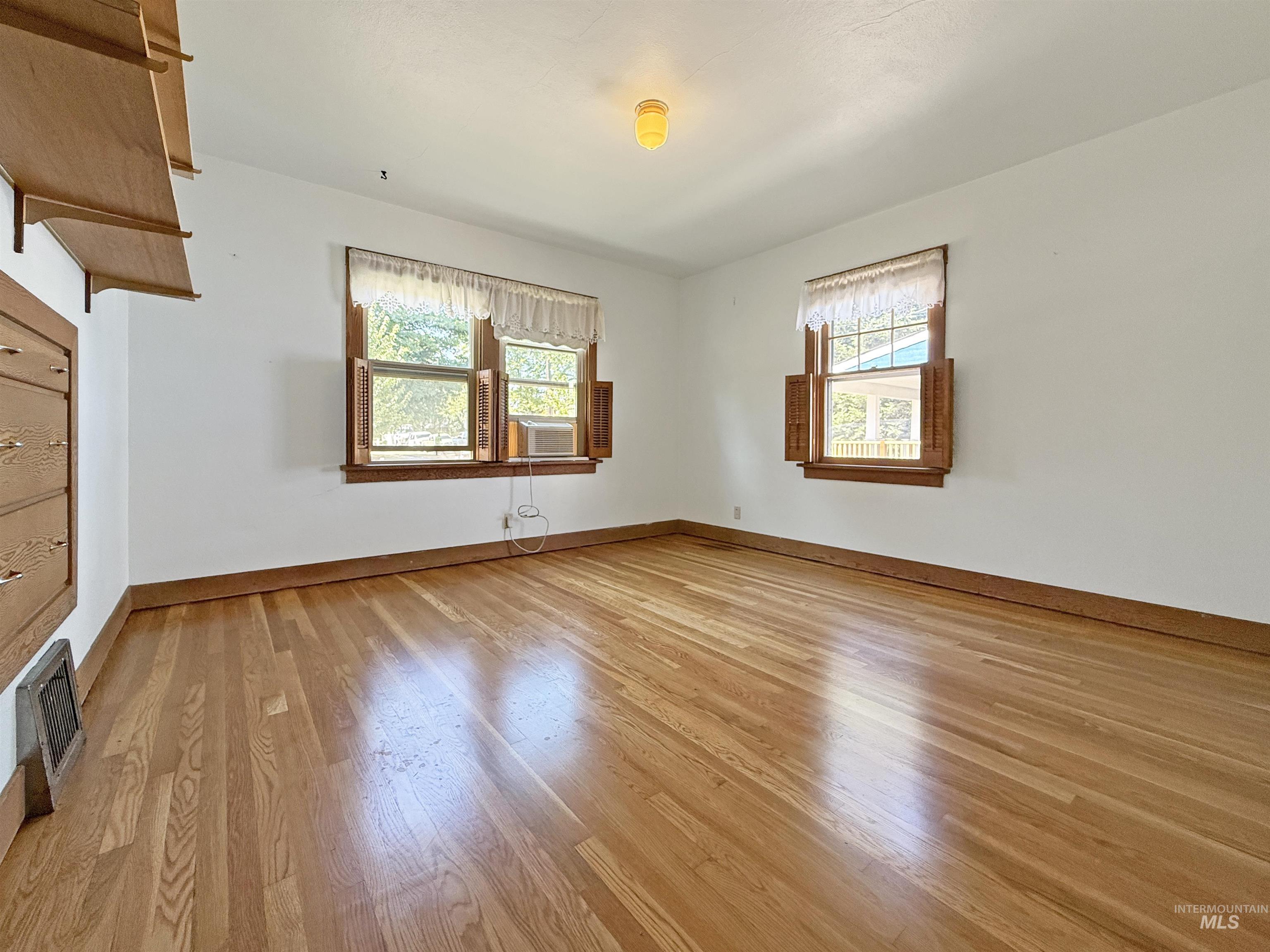 Empty room with baseboards and light wood-style flooring