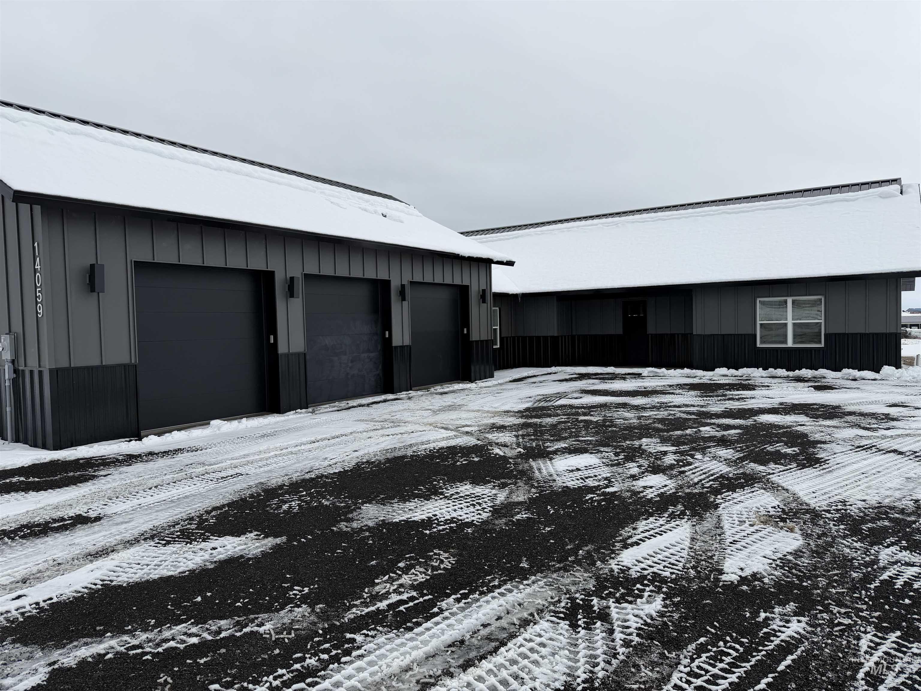 Snow covered property with a garage