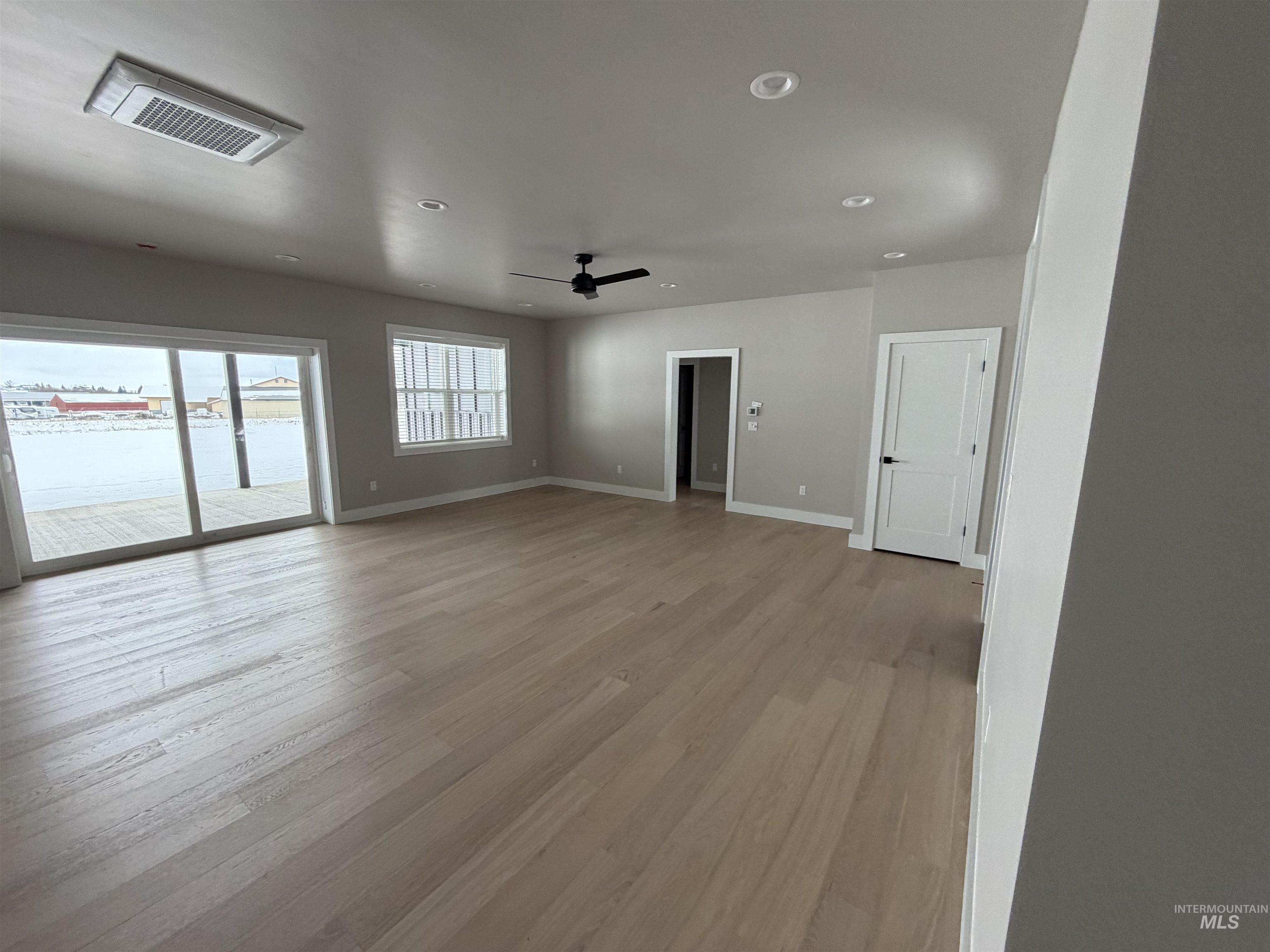 Empty room featuring light wood-type flooring, a water view, recessed lighting, and a ceiling fan