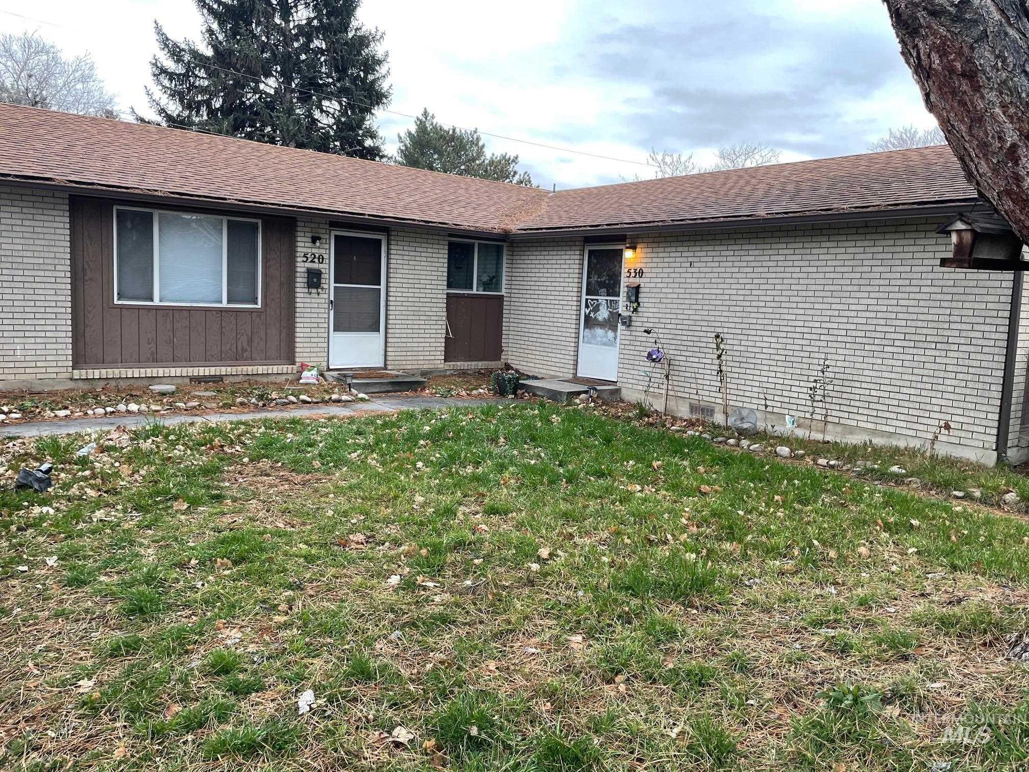 Single story home with a front lawn, roof with shingles, and brick siding