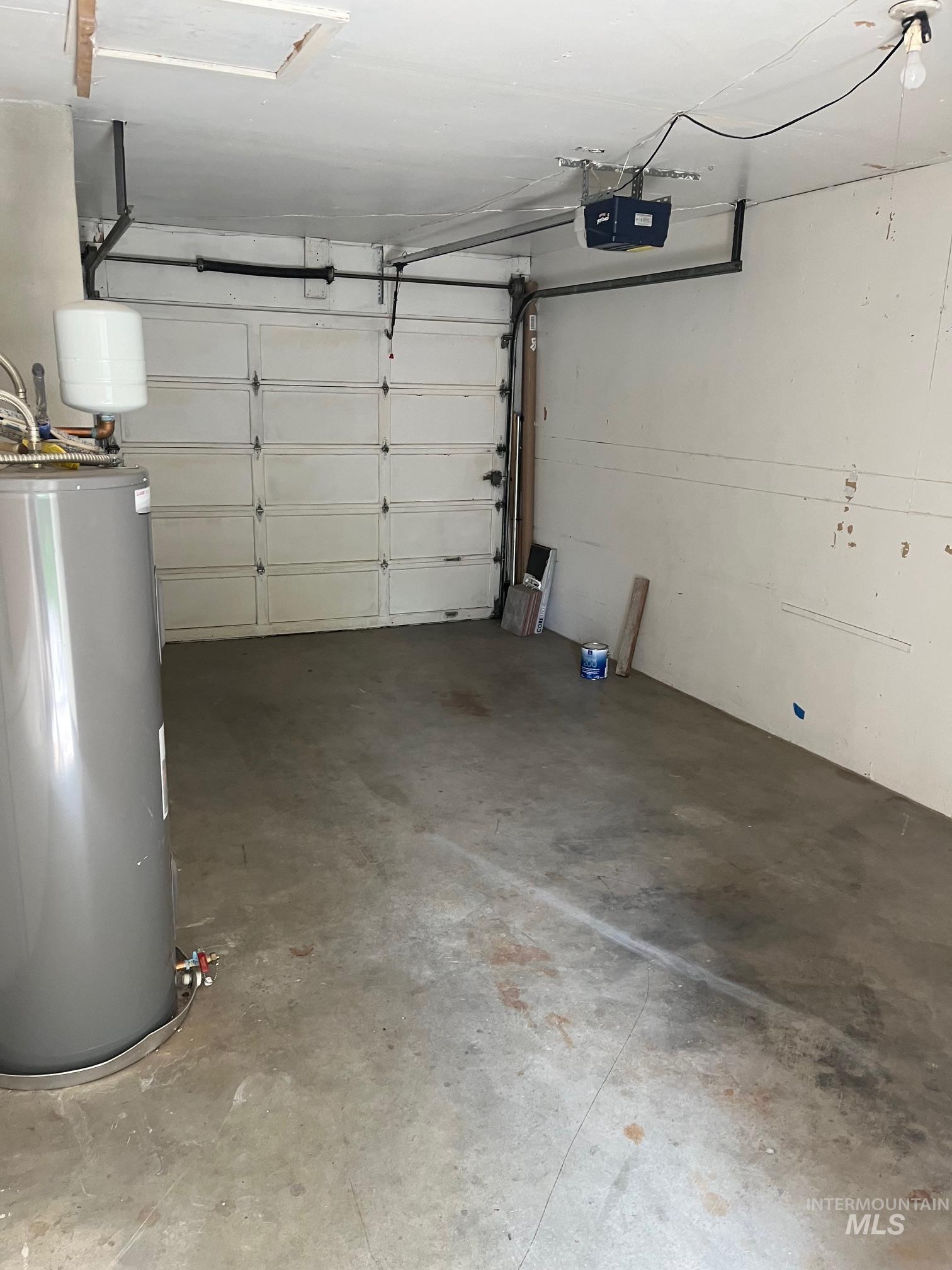Garage featuring water heater and a garage door opener