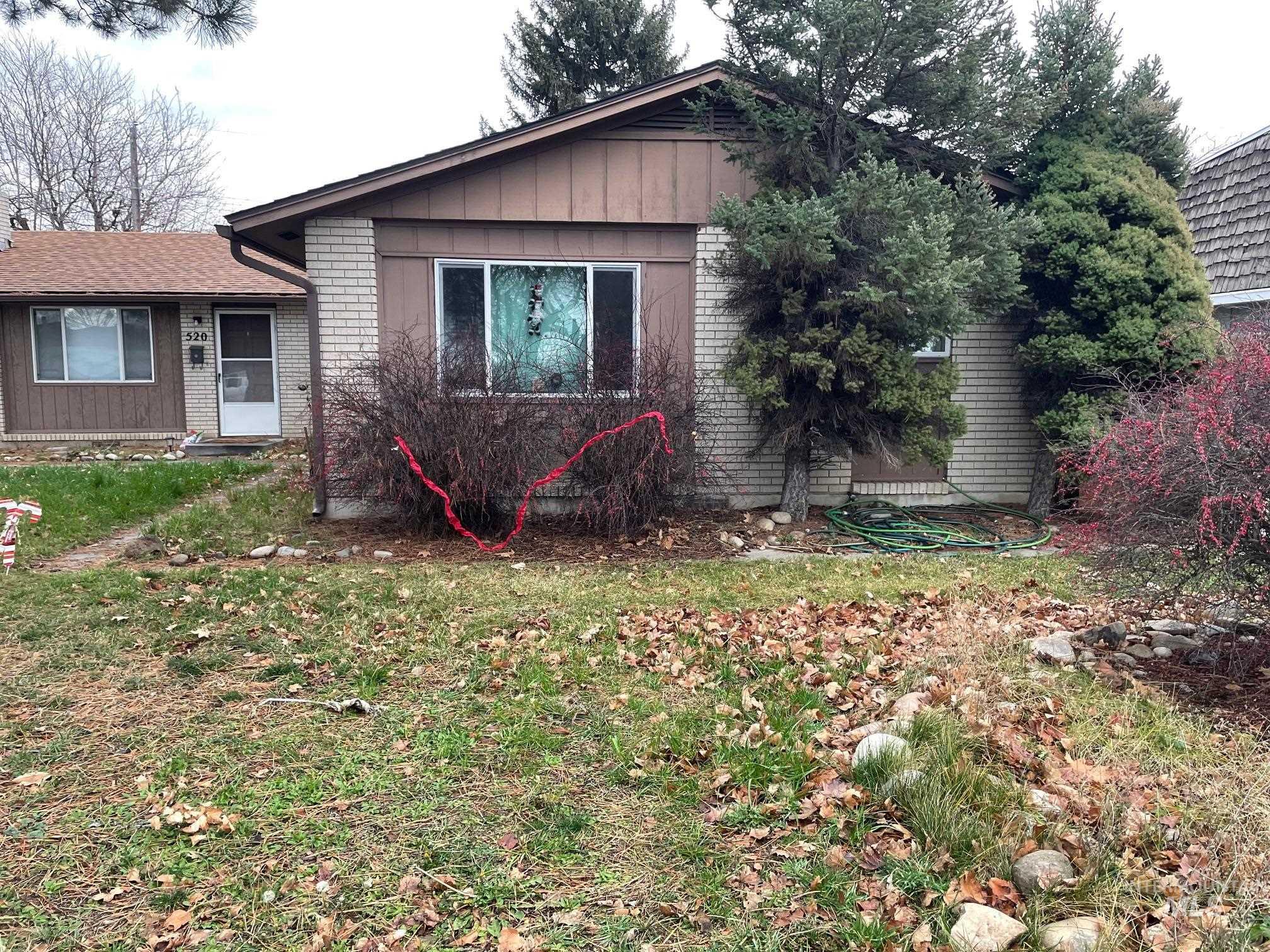 View of front facade with brick siding, a front yard, and board and batten siding