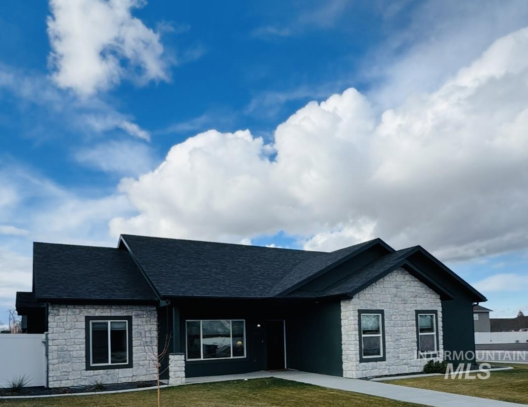 View of front facade with stone siding and roof with shingles