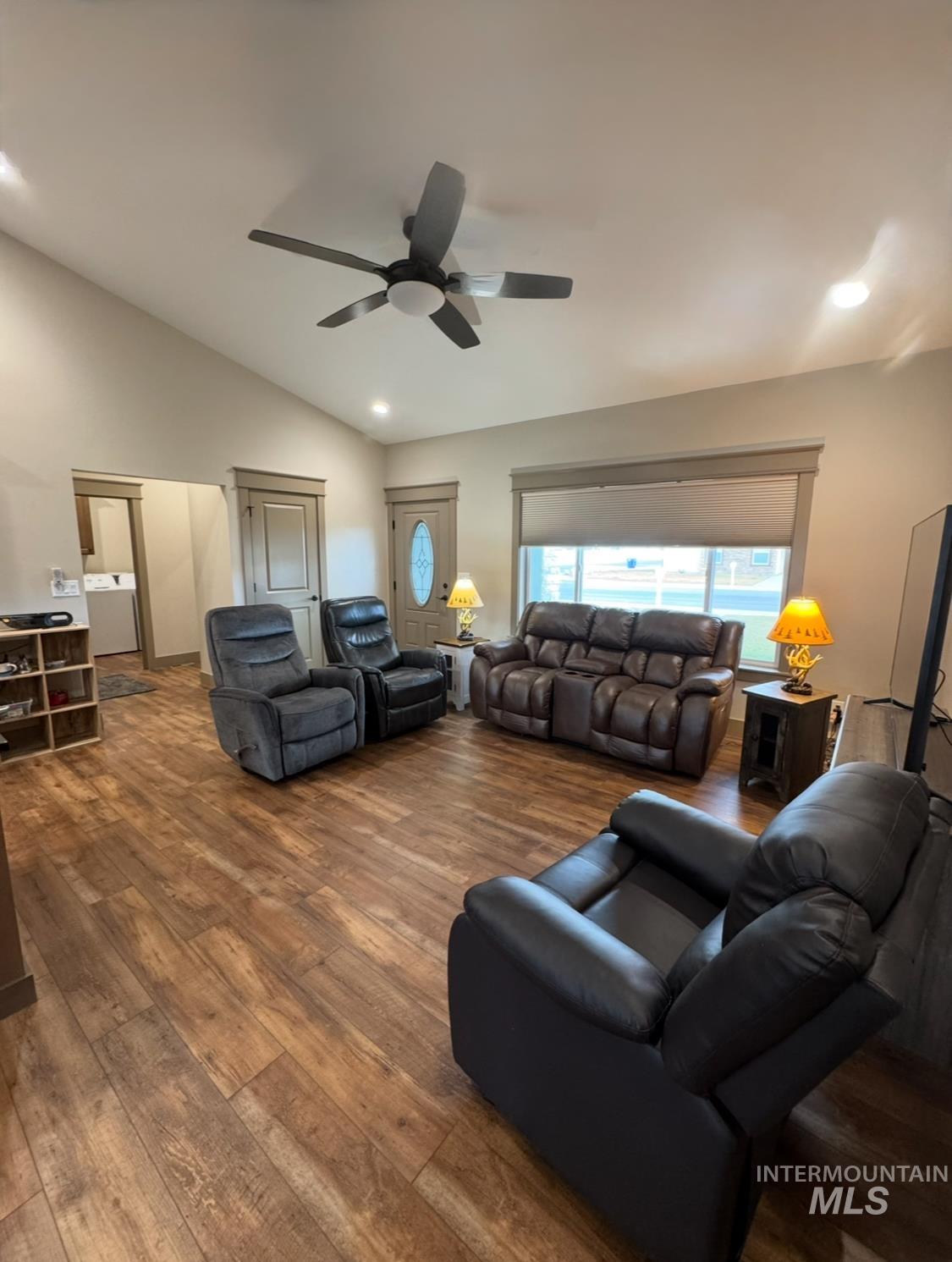 Living area featuring vaulted ceiling, hardwood / wood-style flooring, washer / dryer, a ceiling fan, and recessed lighting