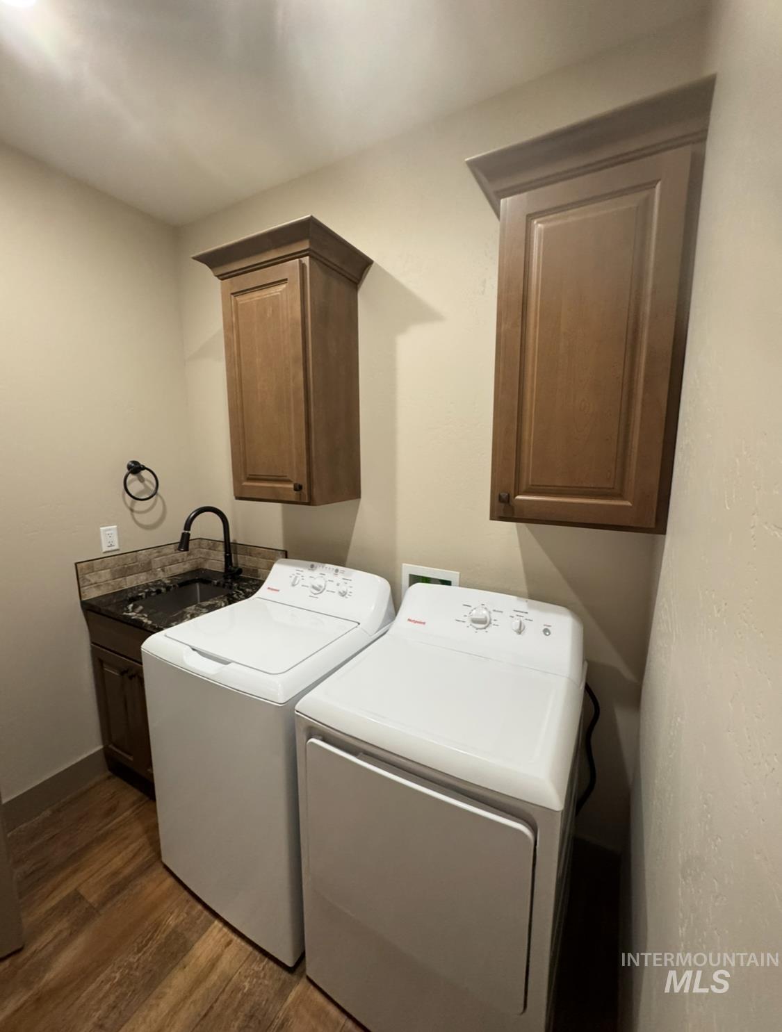 Laundry area with cabinet space, dark wood-type flooring, and washing machine and clothes dryer