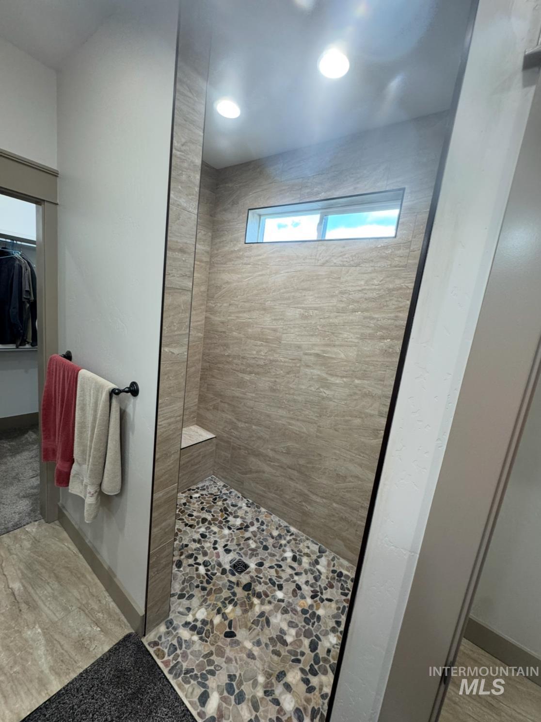 Bathroom with a walk in shower, light wood-style floors, a walk in closet, and recessed lighting