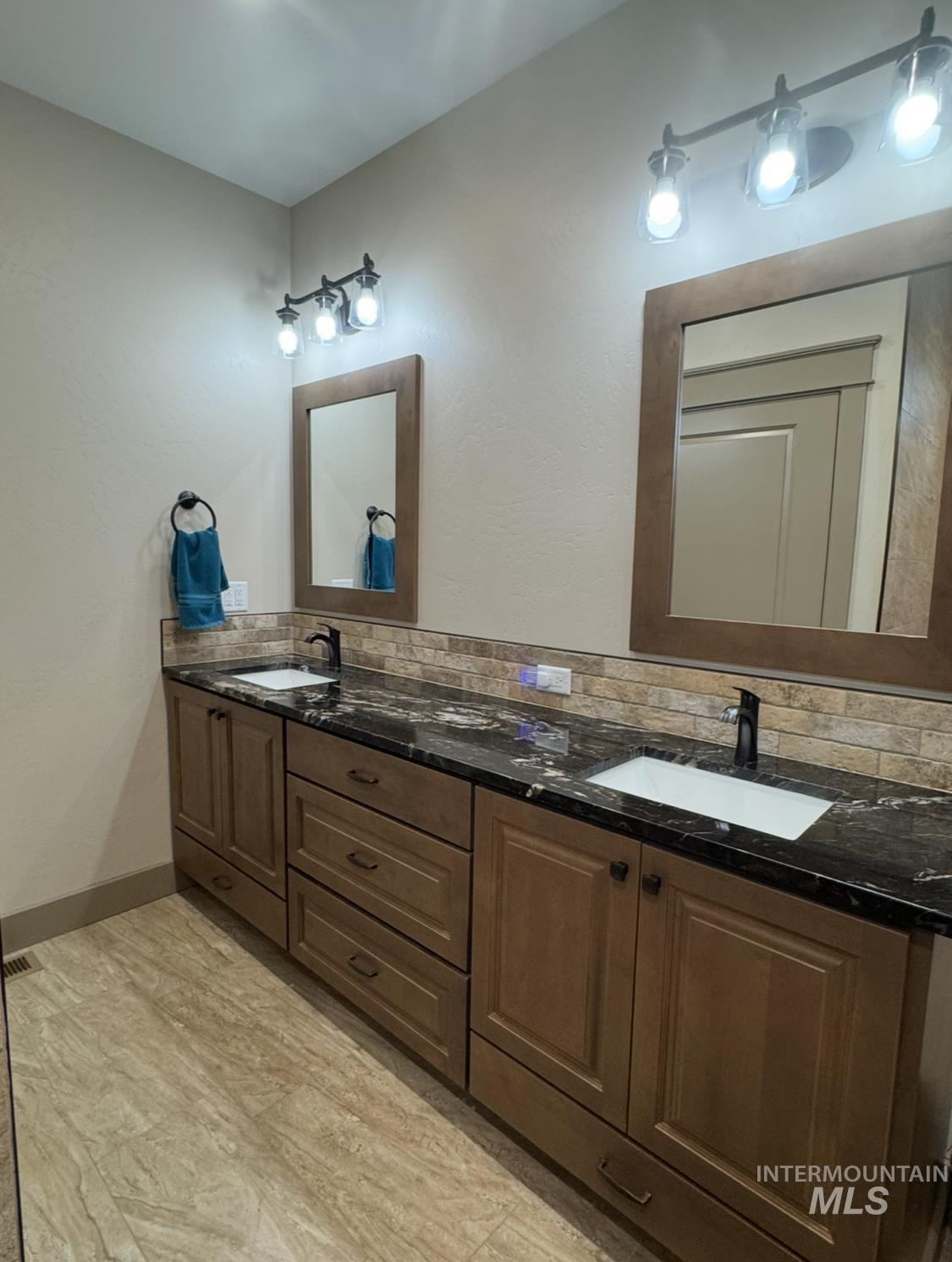 Full bathroom with double vanity and backsplash