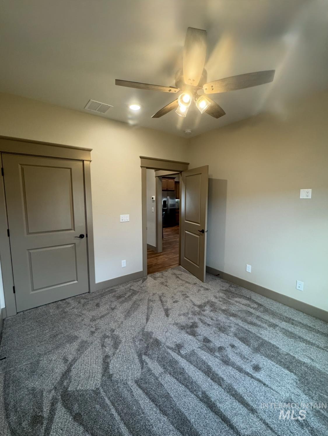 Unfurnished bedroom featuring carpet floors and a ceiling fan