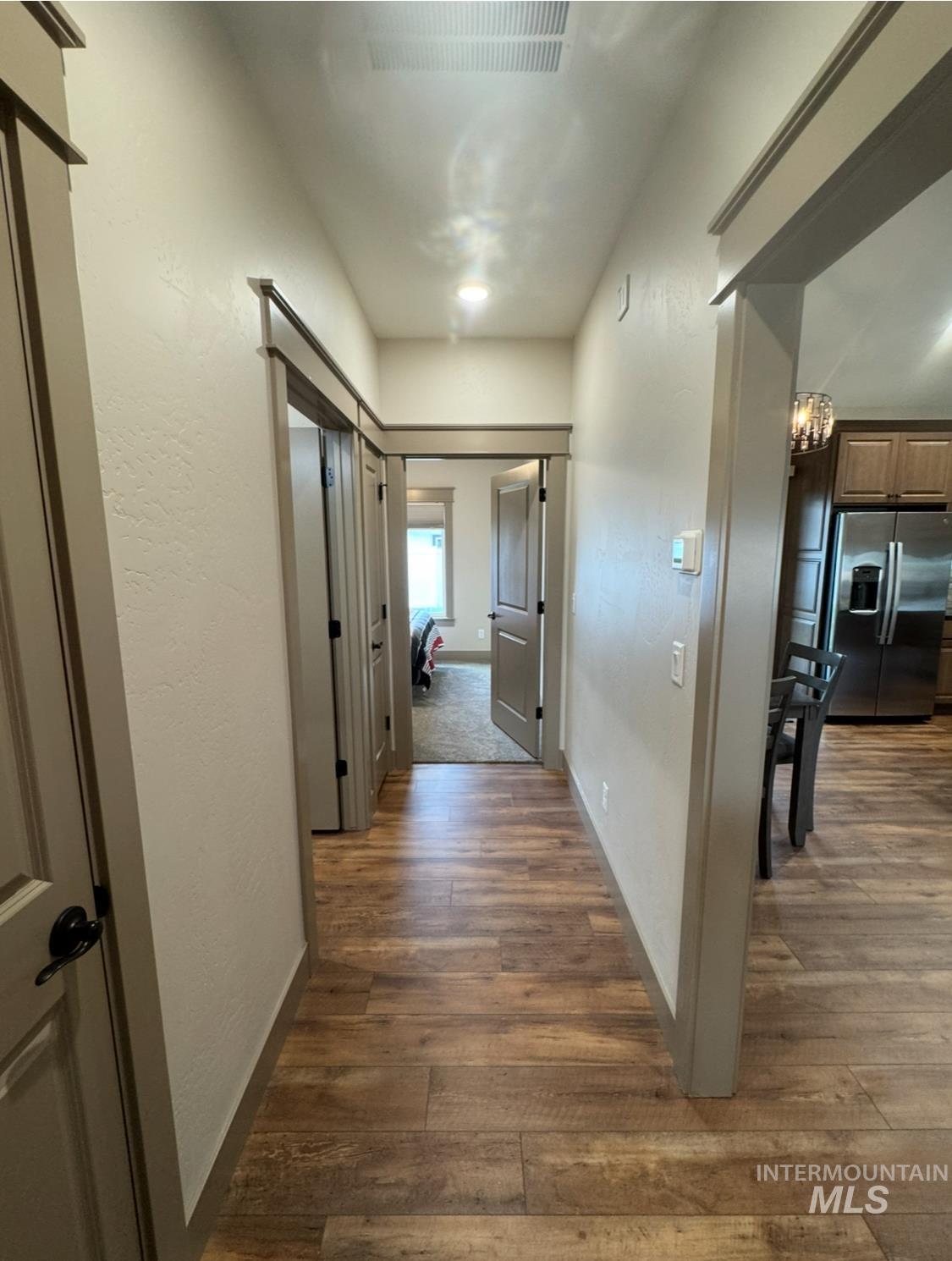 Hallway featuring dark wood-style floors and a chandelier